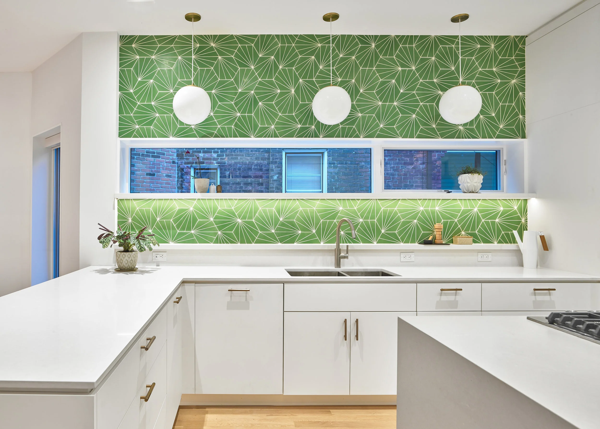 The kitchen is laid out to be comfortable for two people to cook simultaneously. A wide gas range is integrated in the island with a discreet downdraft hood.