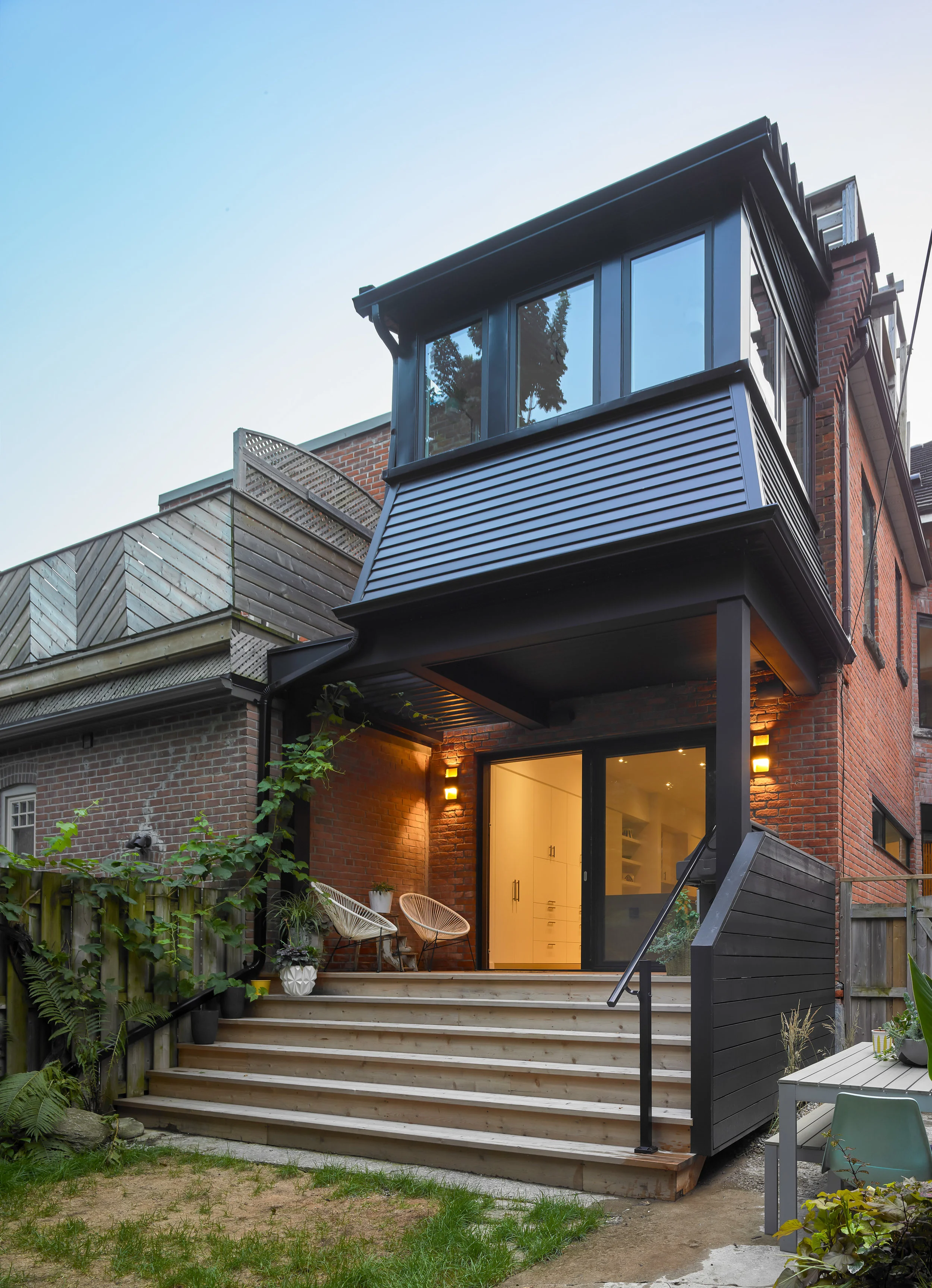 The rear sunroom is re-clad in black siding match with the new windows.