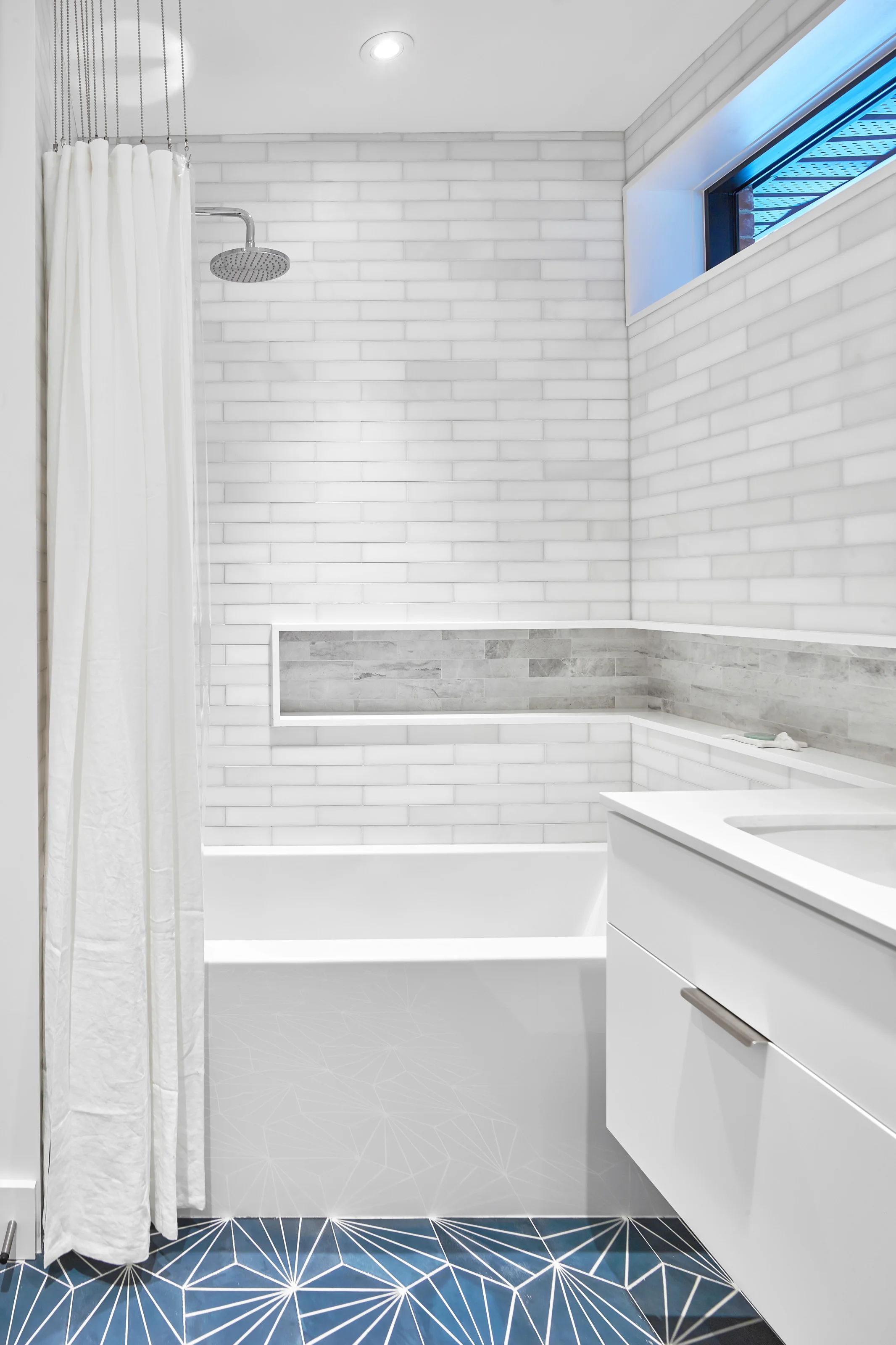A shower niche aligned with the vanity top is a perfect place for storing soaps and shampoos.
