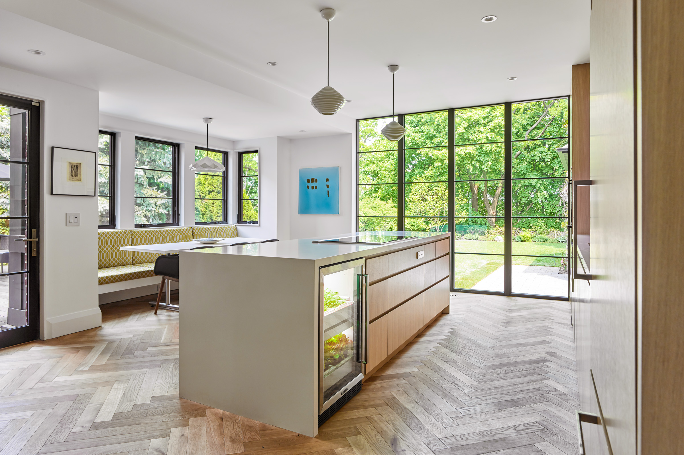 The kitchen is lit by generous floor-to-ceiling windows that afford views out over the lush green yard and onto the Humber ravine. Inside, the island incorporates an ‘urban cultivator’ for growing fresh greens and herbs year-round.
