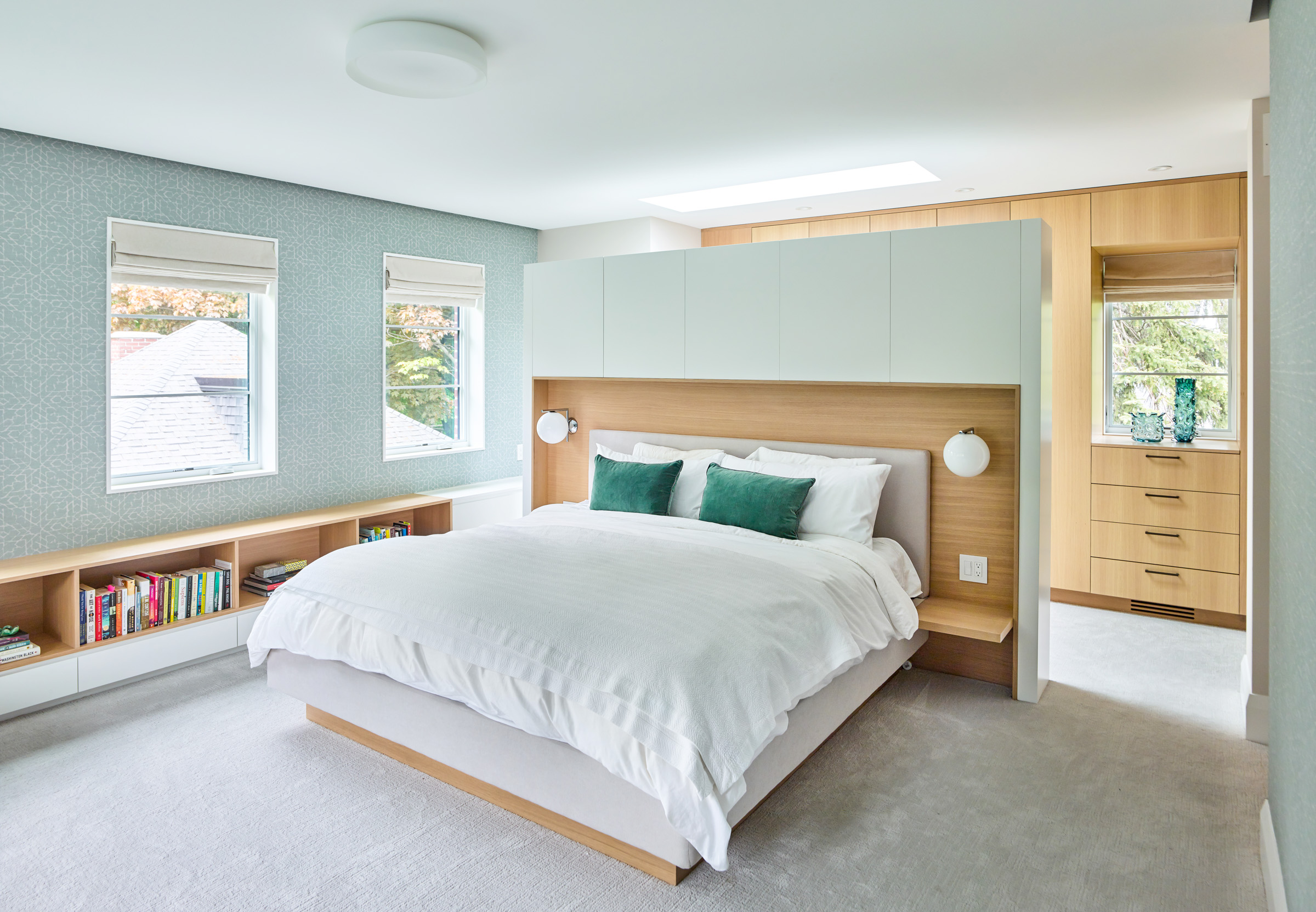 Upstairs, the new master suite becomes a spacious adult retreat overlooking the rear yard. Calming tones of pale green are paired with light woods and soft fabrics to create a serene environment for rest and relaxation.