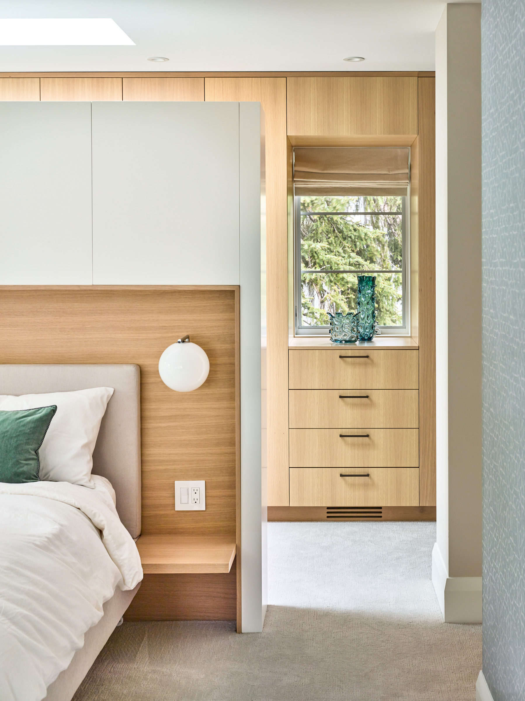 The headboard partition wall anchors the bed within the room, and provides a unique boutique hotel-like layout.
