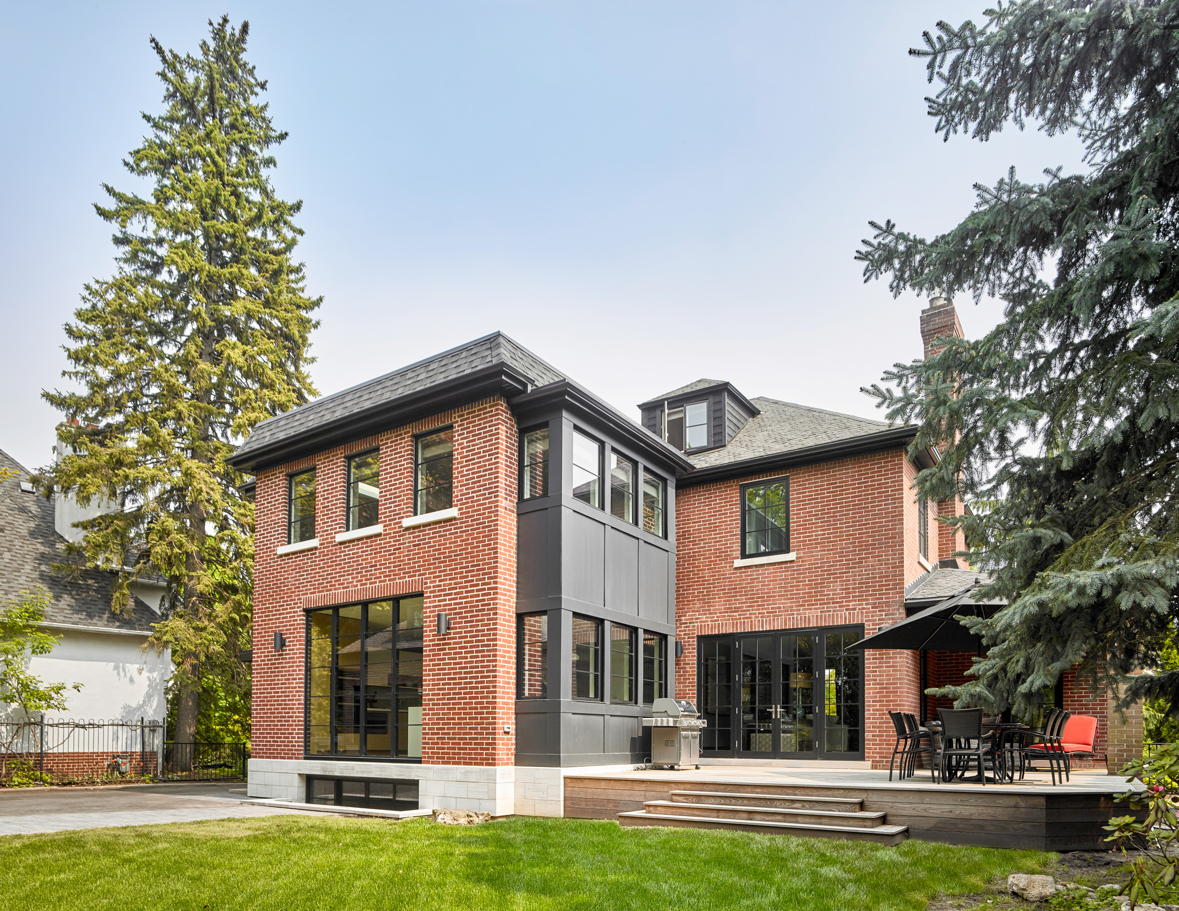 The rear 2-storey addition is blended seamlessly with the existing home; a red brick was selected to match the existing home, and the existing home itself is upgraded to provide larger, better performing windows that further help blend the old with