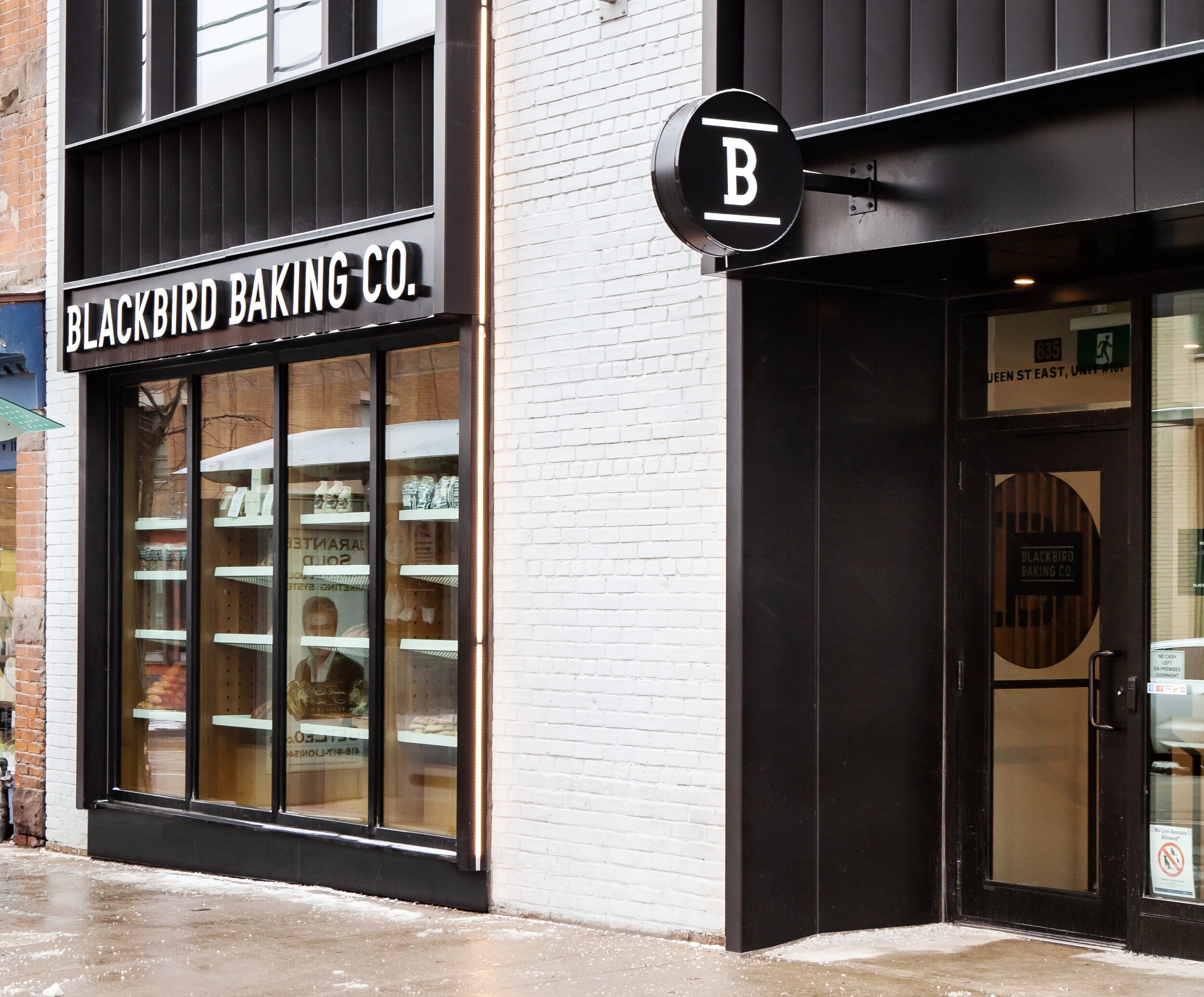 From the street, the fresh baked bread products are displayed to passing pedestrians within the valuable amount of window space. Reminiscent of the bread-packed storefronts of old European bakeries, the street-level display entices people in to the