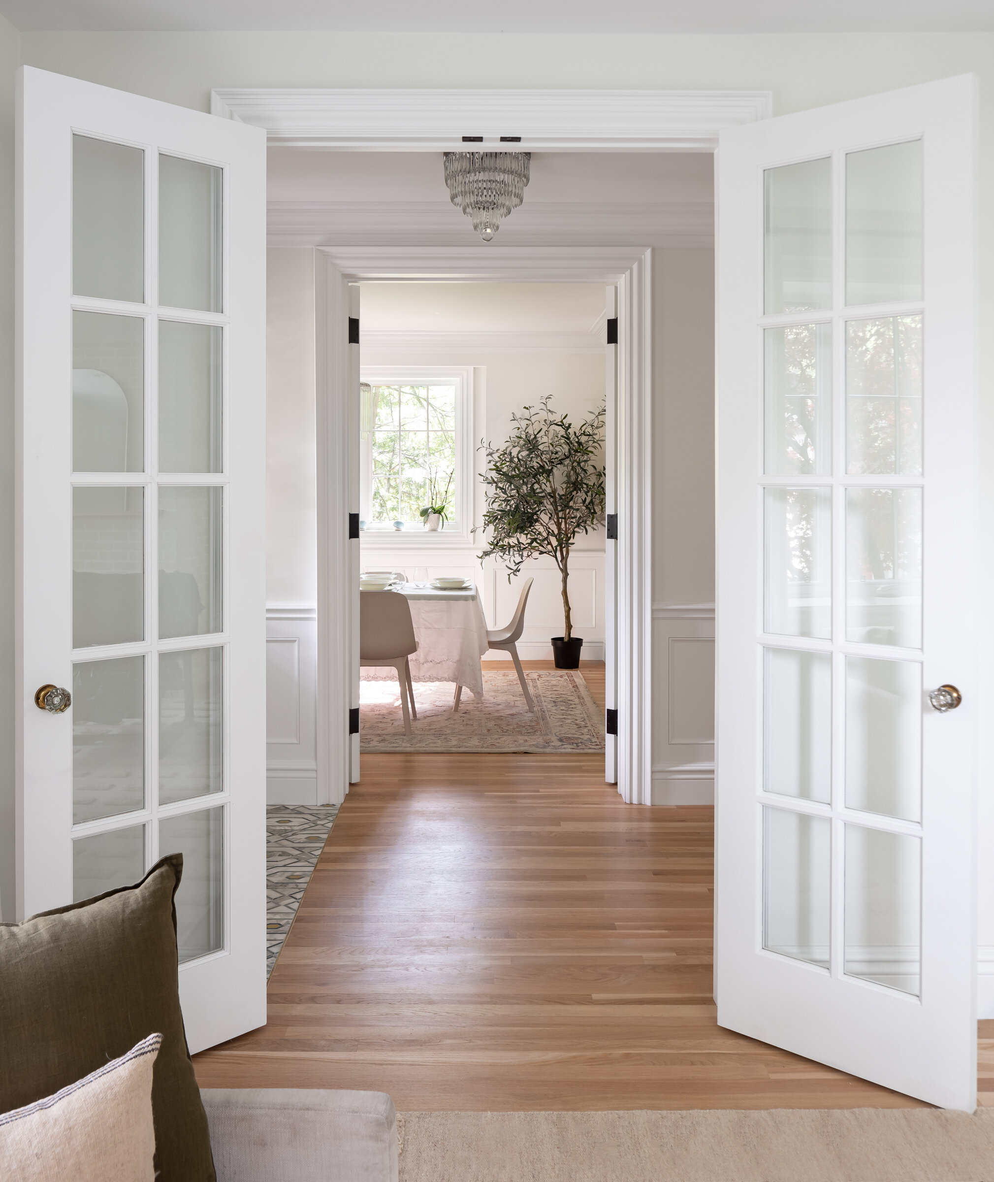 The more formal front of the home embraces the spatial layout of the original house. The living room and dining room flank the foyer, with gracious French doors that provide framed views through the spaces, while also allowing them to be enclosed w