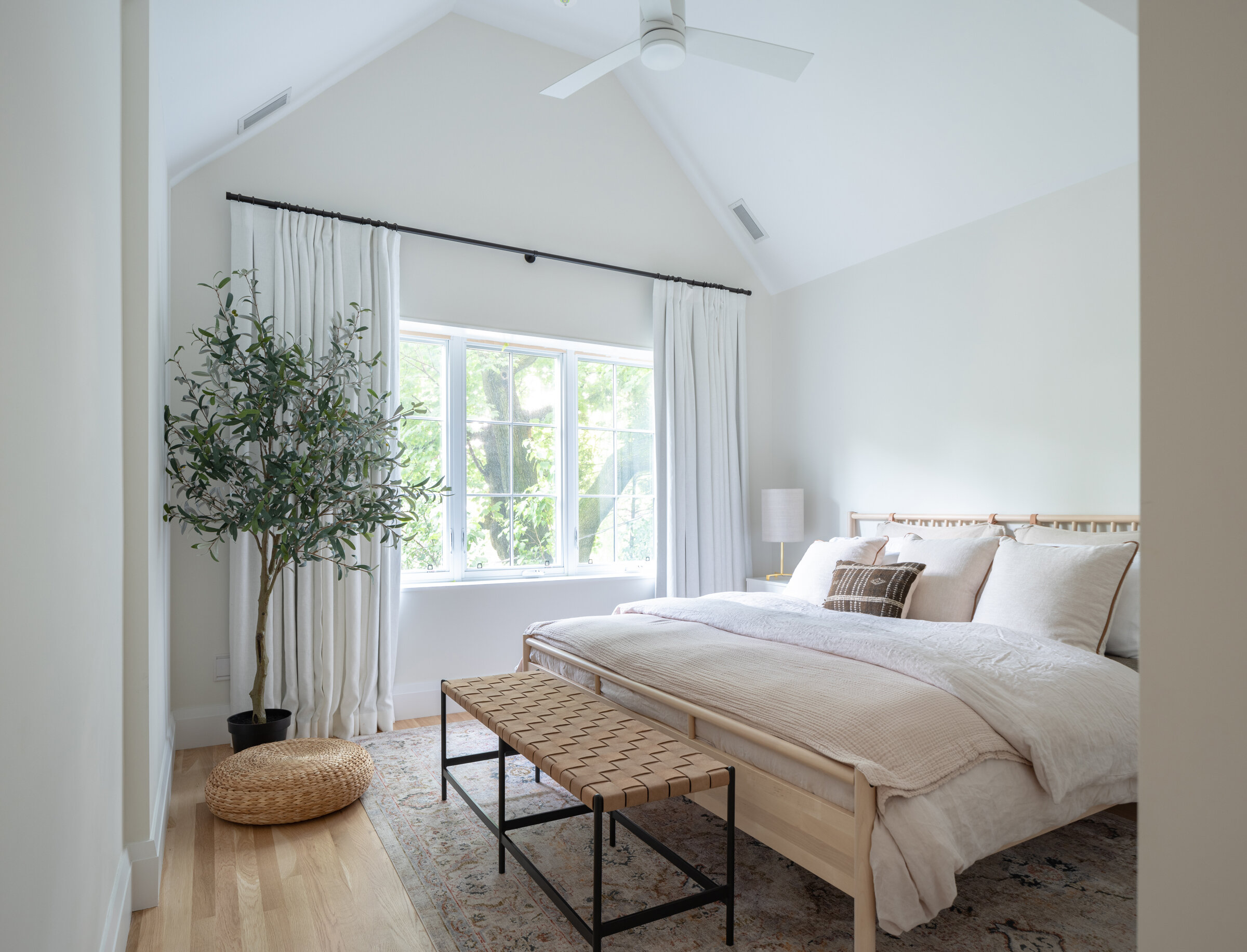The ceiling in the master bedroom was opened up to create a vaulted ceiling. Finished with a palette based on whites and neutrals, the room feels airy, light, and serene.