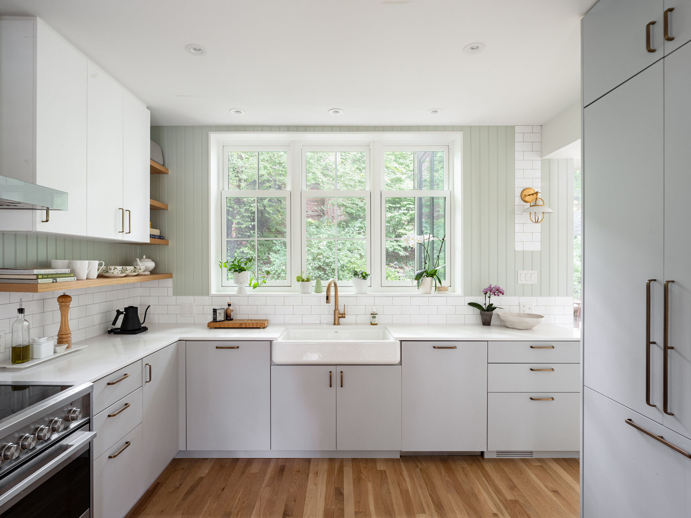 The kitchen acts as the transition point between the formal spaces in the front of the house and the more contemporary, laid back rear. Traditional touches such as the large ceramic apron front sink are blended with contemporary flat front cabinets