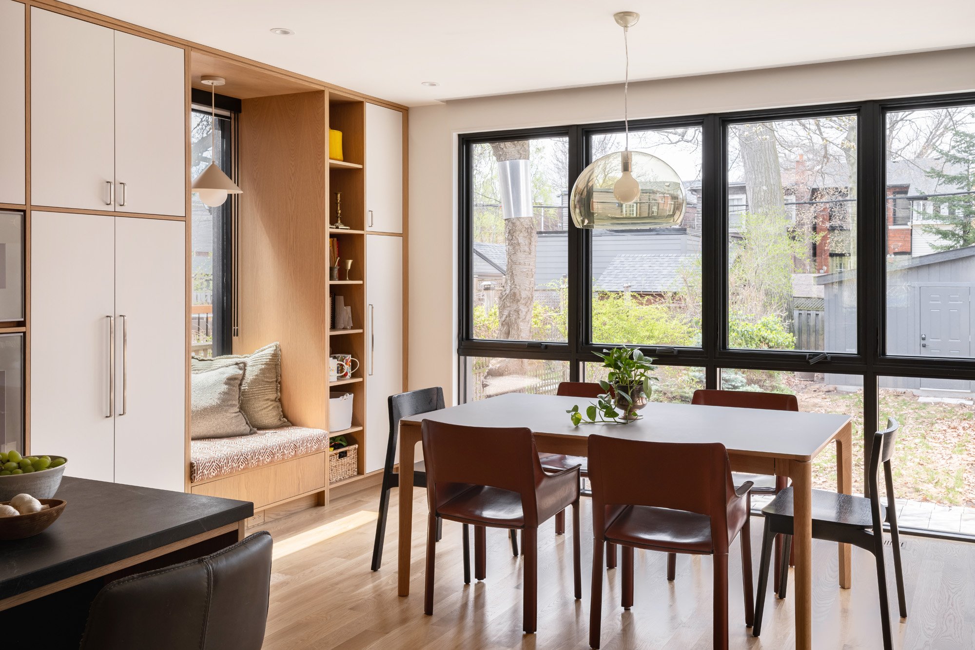 Large windows were added at the back to create views of the beautiful mature trees in the rear yard, and to take advantage of the west afternoon and evening light when dining. A mix of new and vintage furniture pieces creates a playful mix of colour