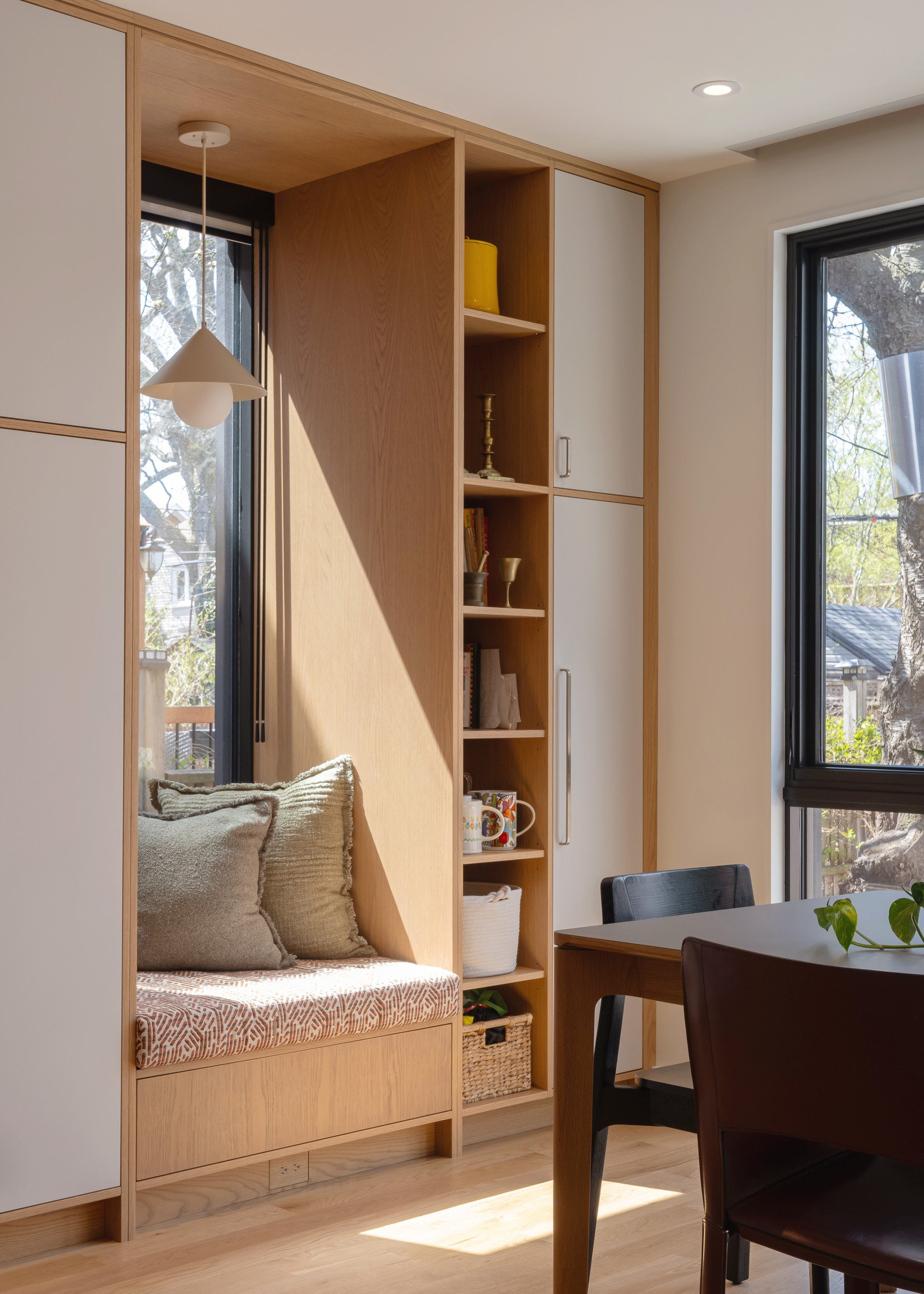 A new window and window bench were incorporated along the south side of the kitchen, bringing in ample light throughout the day, and offering somewhere to curl up with a cup of tea and book near the kitchen and eating areas.