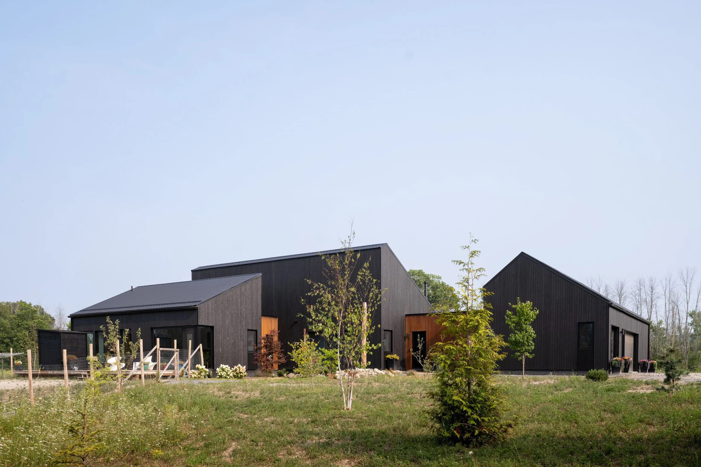 From left to right, separate volumes house the primary suite, the main living areas, and a large woodworking shop.  