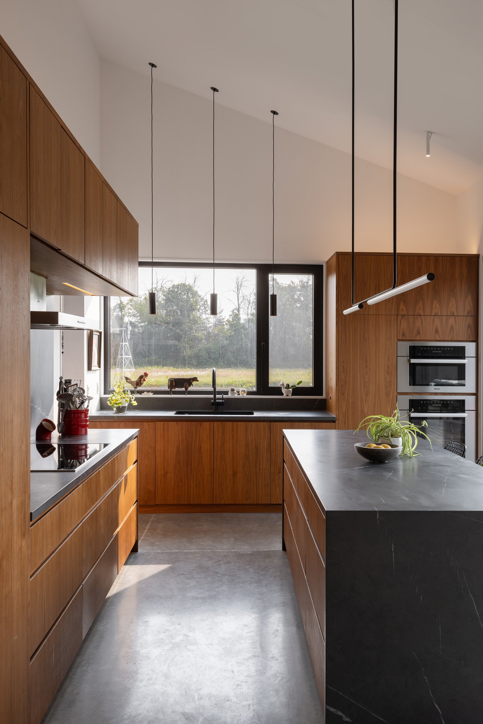  The kitchen features warm wood millwork with clean lines, that contrast with the porcelain countertops and backsplash. Durable, hard-wearing finishes were a priority. The heated polished concrete floors used throughout are both a striking material, 