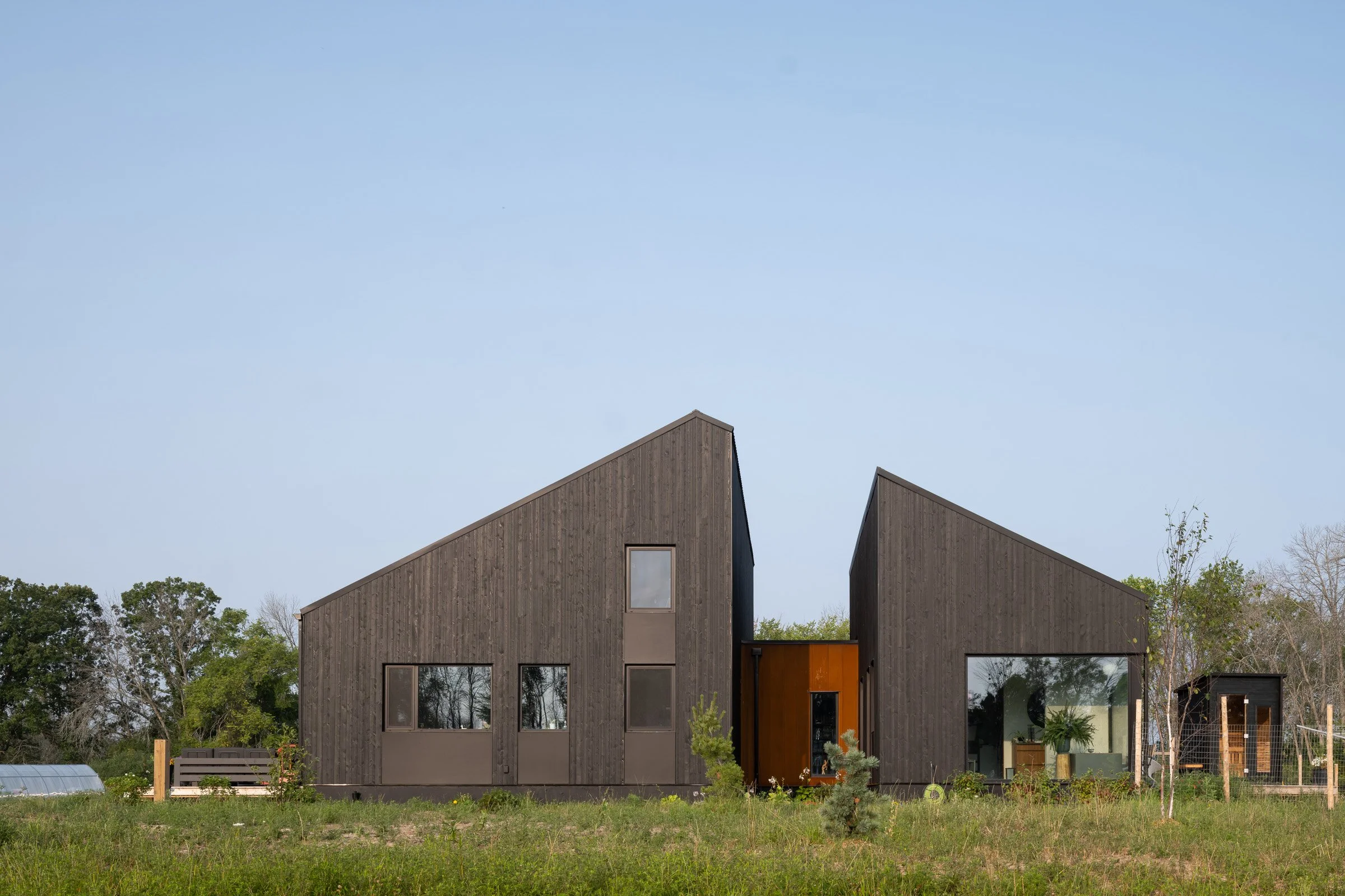  Simple barn-like forms were sliced, pulled apart, and then joined by corten clad passageways, or “links.” Over time as the building settles into the landscape, the surrounding meadow will infiltrate the spaces opened between the volumes, bringing na