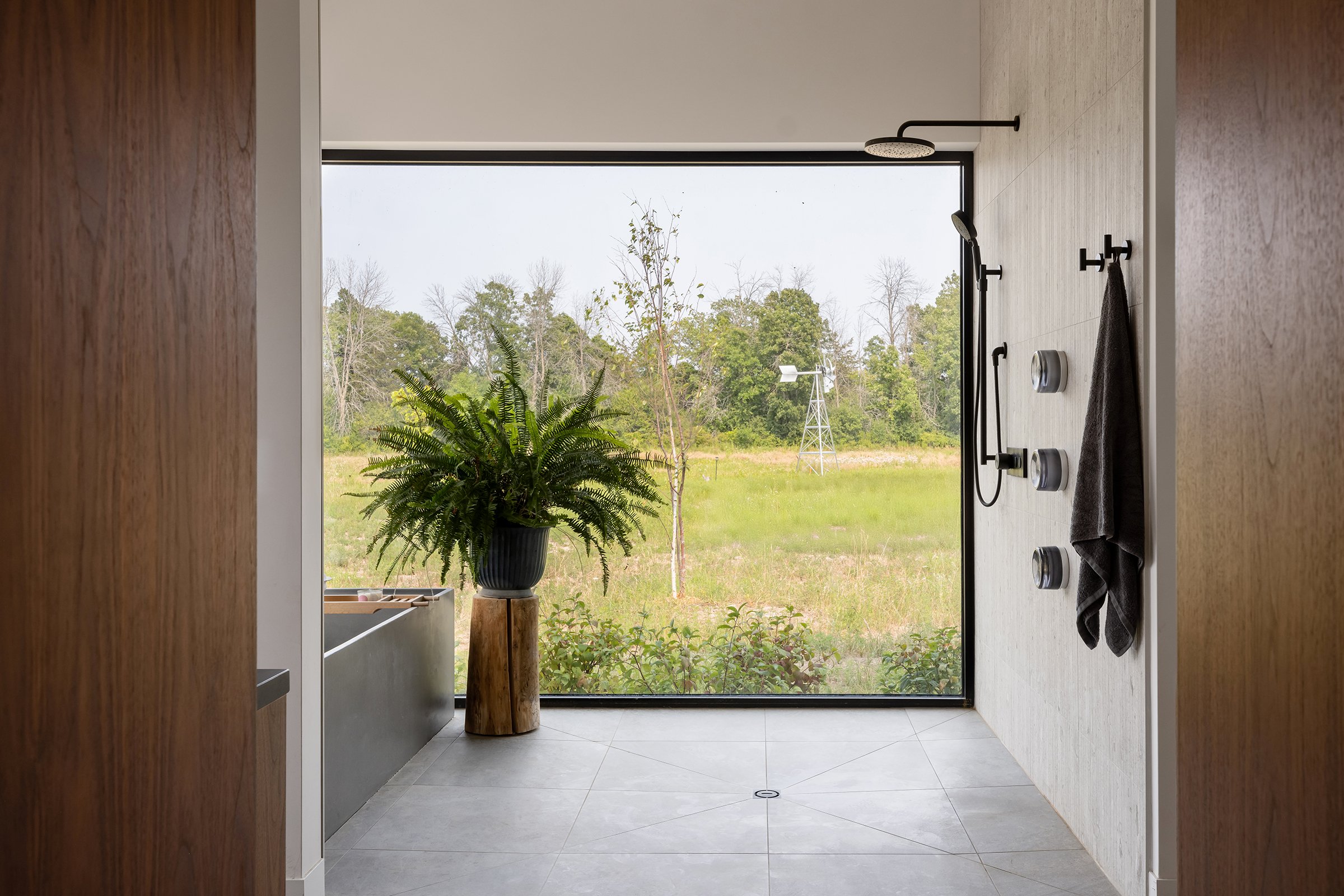  The large primary bathroom incorporates double vanities and a spacious walk-in wet room that has both a shower and a freestanding concrete tub. The property is so private that 8 foot tall windows stretching all the way to the floor could be incorpor