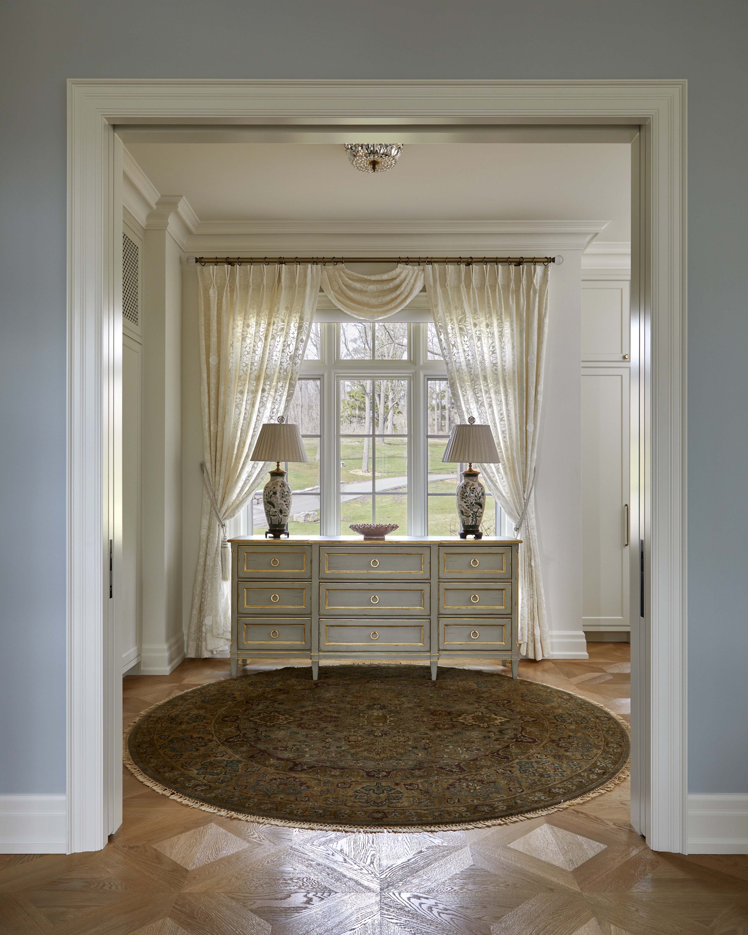  Several small closets were combined to create a proper dressing room. Large pocket doors frame the dresser and window beyond. 
