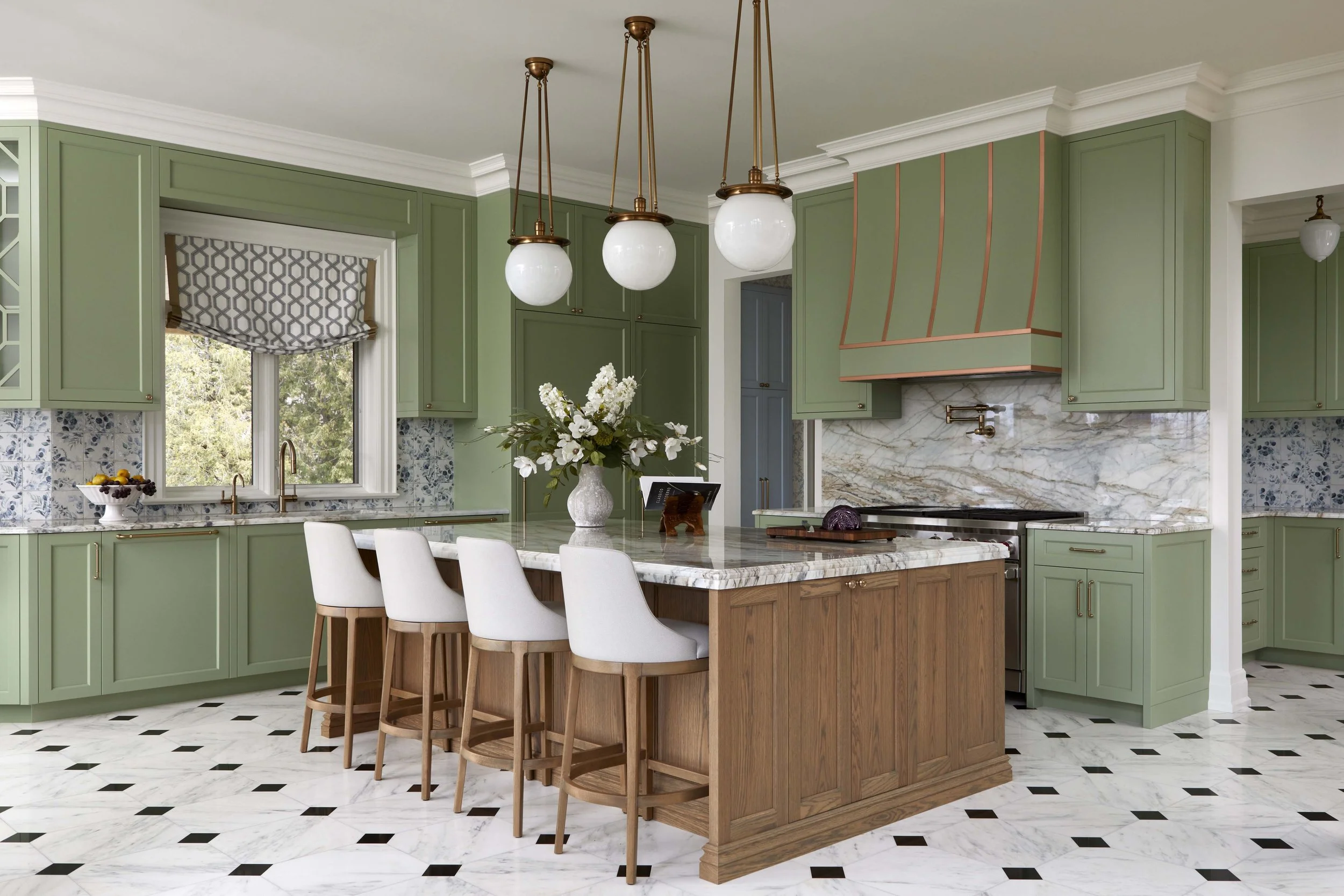  The kitchen is a bright, open space that combines traditional millwork detailing and materials such as the marble flooring and countertops. An existing side entry was closed off to expand the cabinetry and add counterspace and storage. The kitchen i