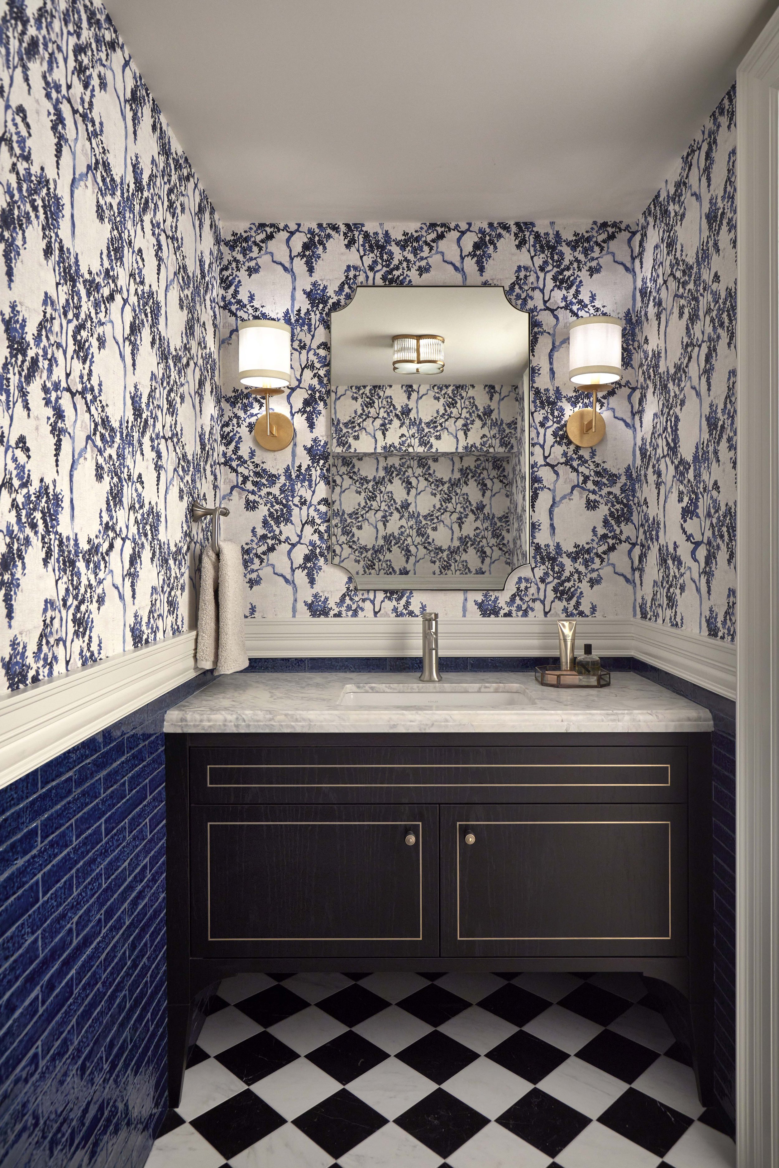  The basement powder room features a contemporary take on a traditional wallpaper and wainscotting design. 