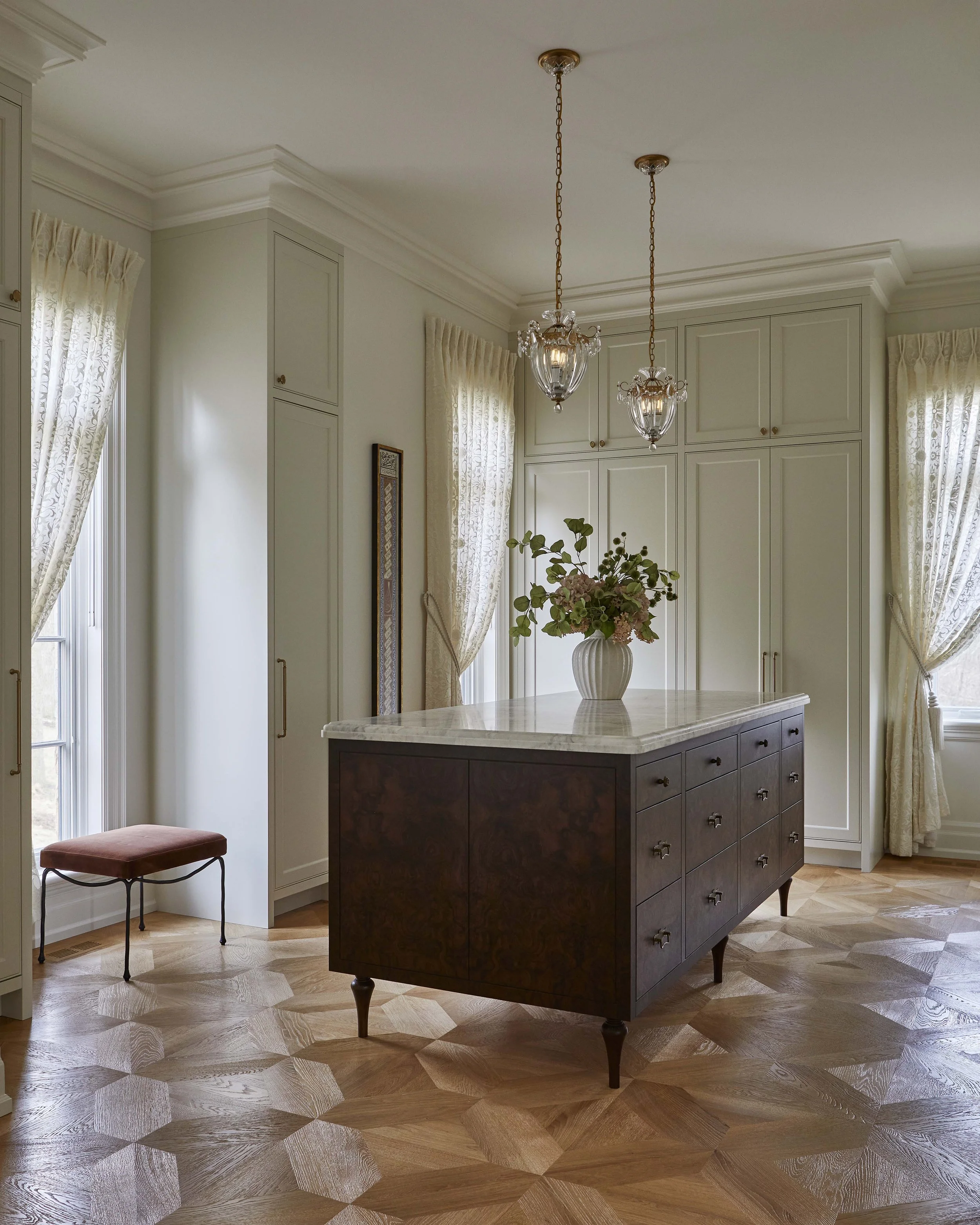  Cream cabinets and lacy sheers contrast with a burled walnut island which anchors the room 