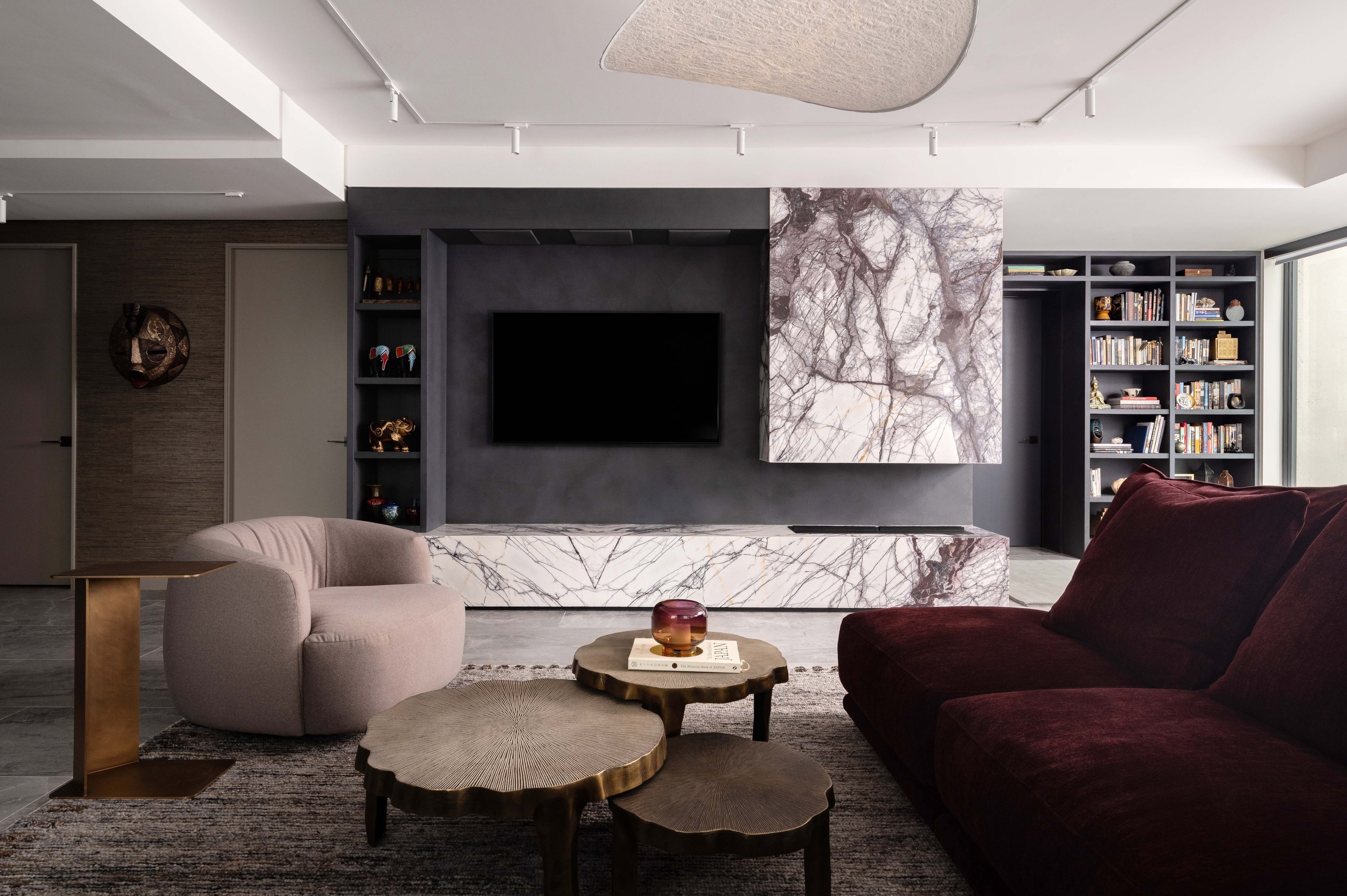  The central focus of the room is the dramatic Lilac Art marble fireplace. The graphic, striking stone becomes its own artwork. The low marble plinth houses the fireplace and offers extra seating space in when hosting a crowd. 