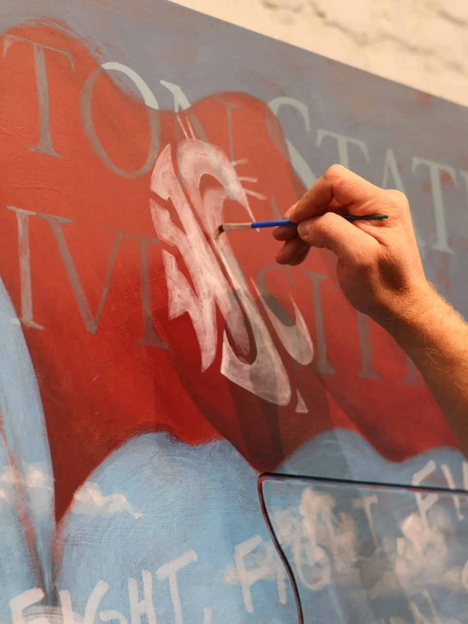 Closeup of ben painting the WSU logo
