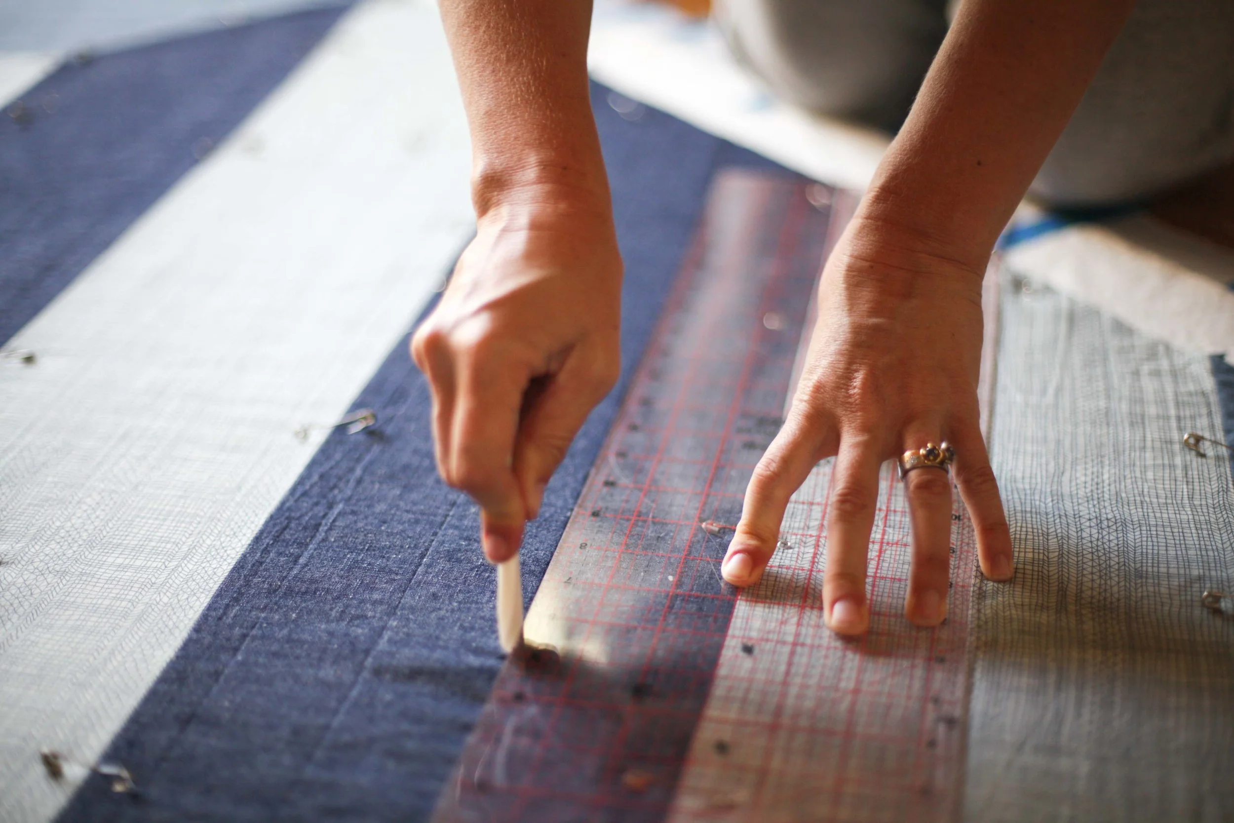 The linen/cotton mix of the denim stripe has a more fixed structure - so two corners of the quilt have straight lines. 
