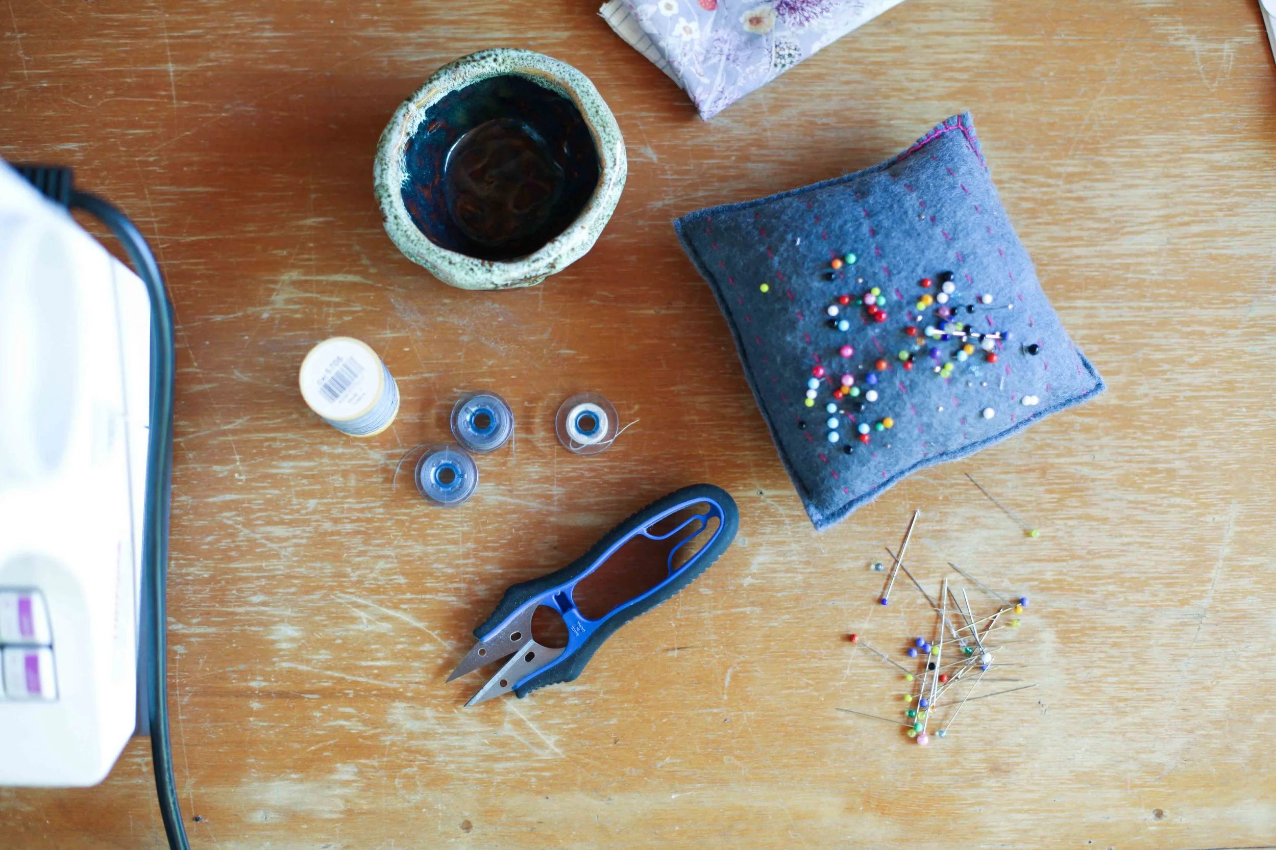 Prewound bobbins, thread-snips, bowl for loose cottons and spare thread. 