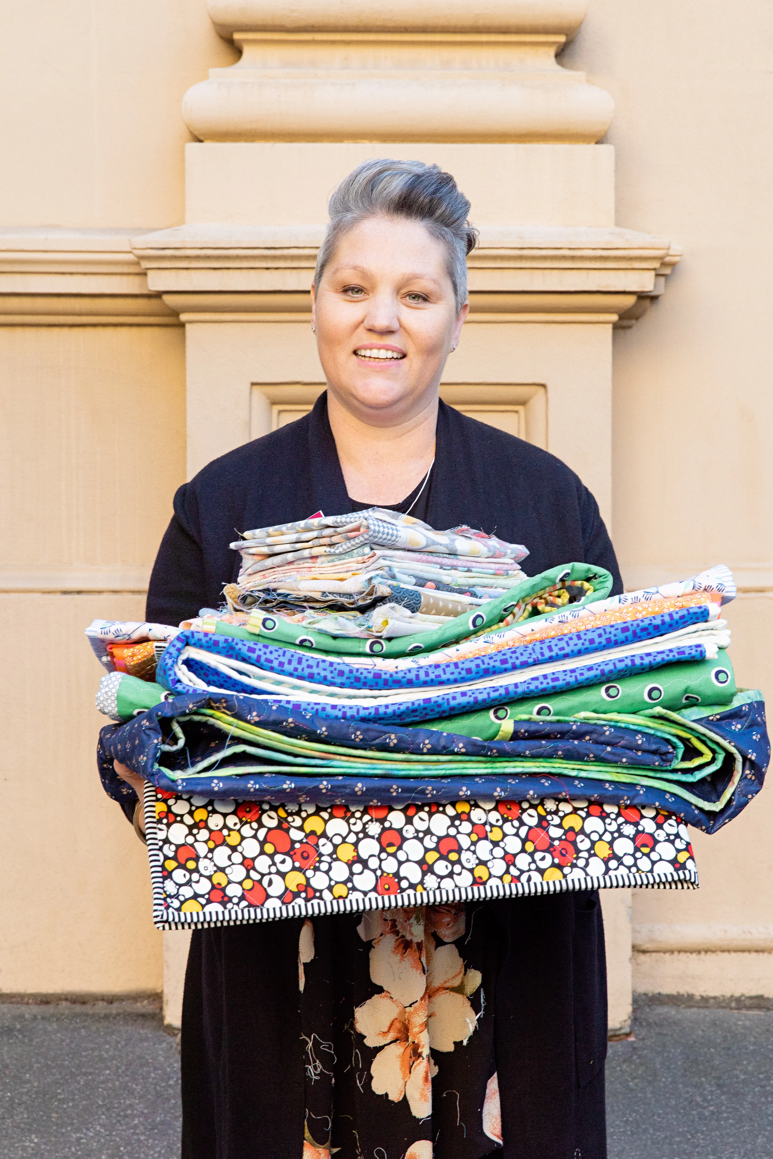 Josephine of the Very Snuggly Quilts program with the quilts made at Soul Craft.