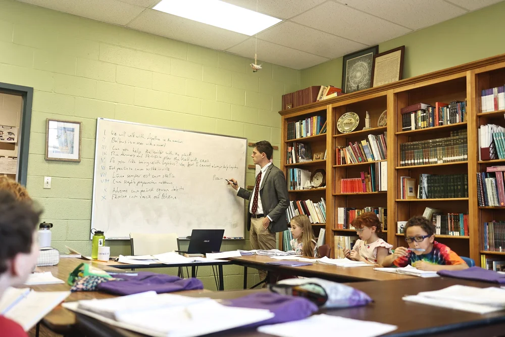 A class in session in front of the school's bookshelves