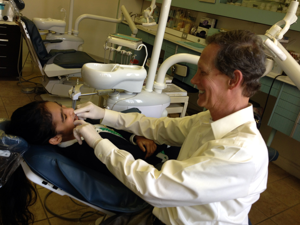 queens orthodontist checking a young patient's braces