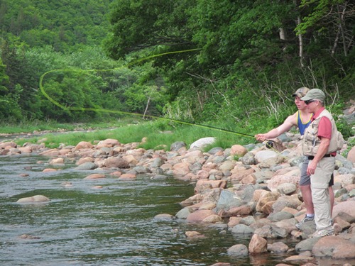 The president of the Chéticamp River Salmon Association, Réne Aucoin showing one of the new summer students, Logan Lapierre a thing or two about fly fishing.