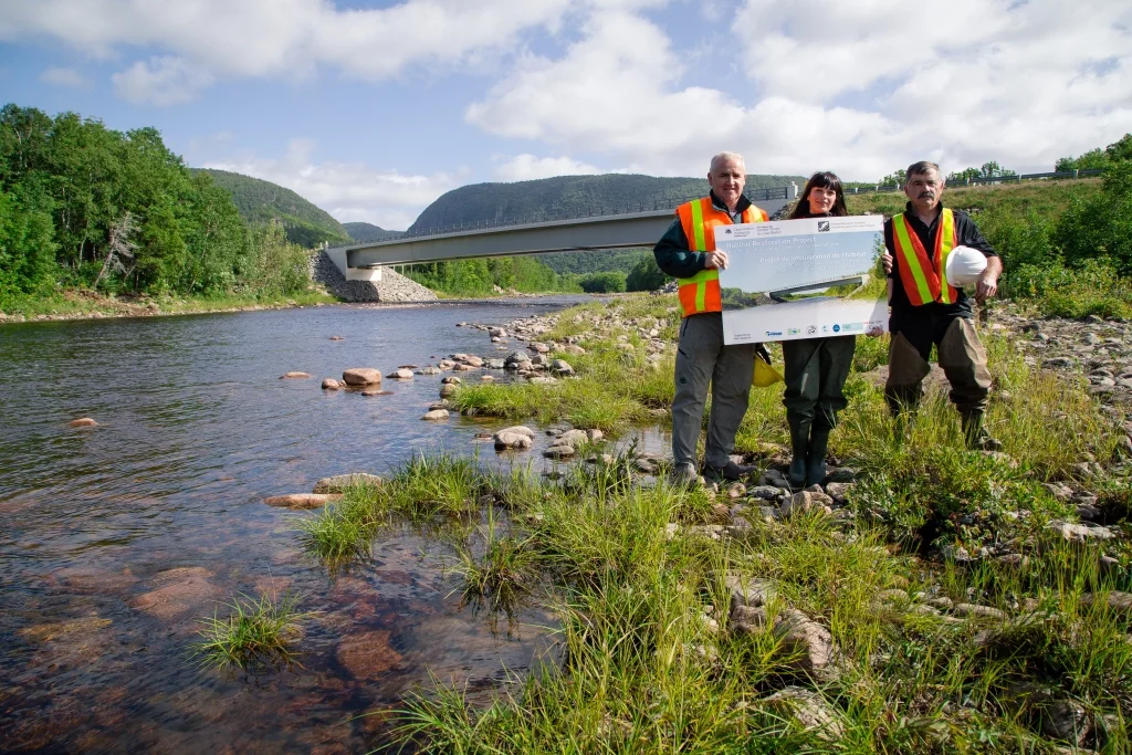 Archie Doucette (Parks Canada), Jillian Baker (CRSA), and Charles MacInnis (project consultant) displaying official project sign at the end of the construction phase.