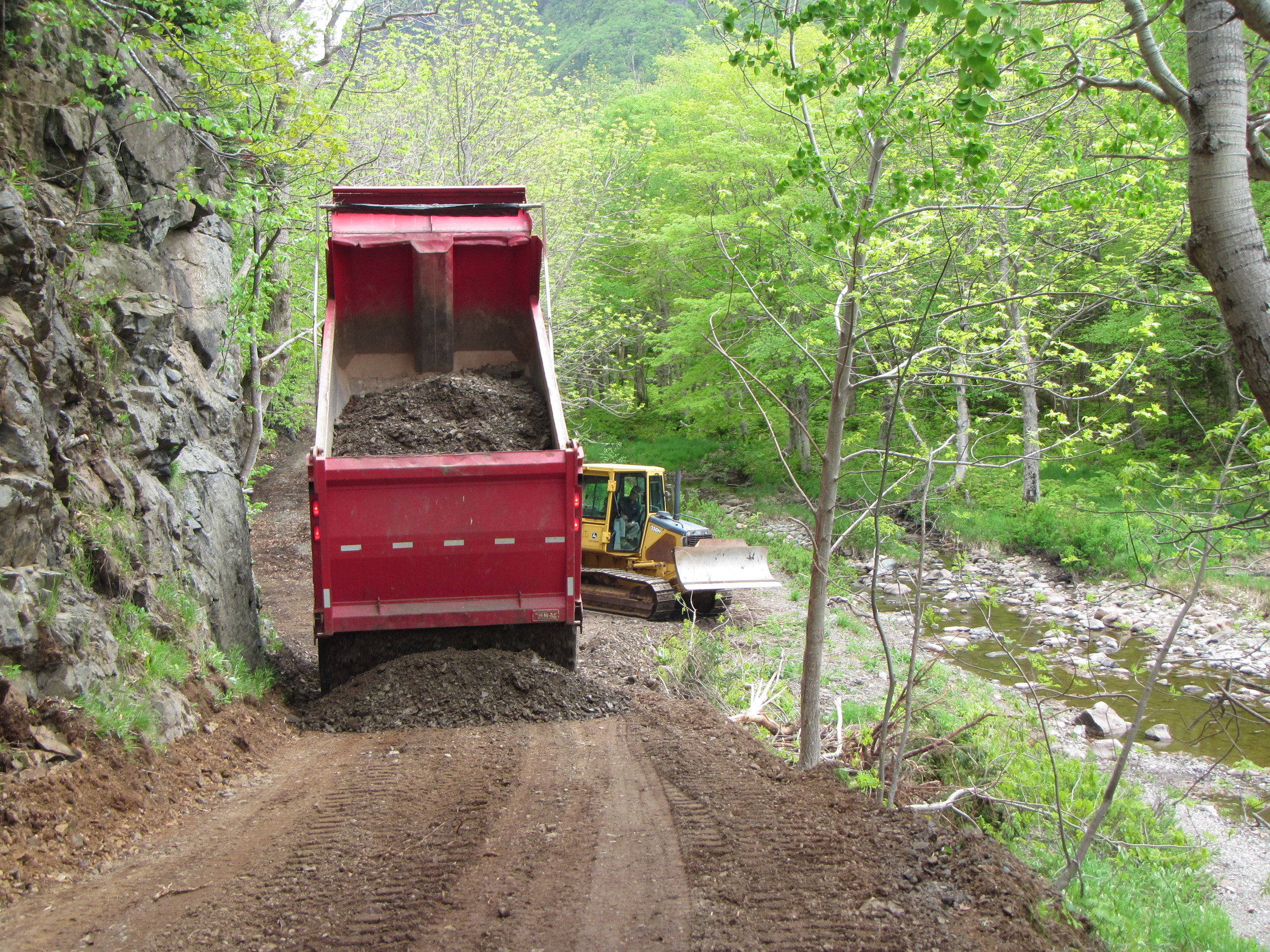 Laying down a new layer of dirt to even out the trail.