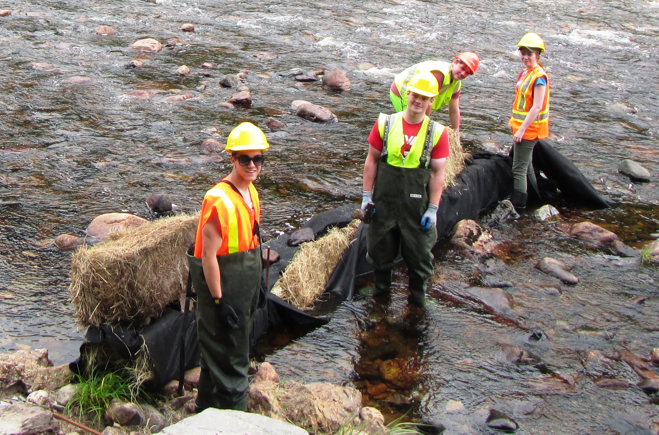 Cheticamp River Salmon Association's student work crew setting up sediment control measures before the start of instream work