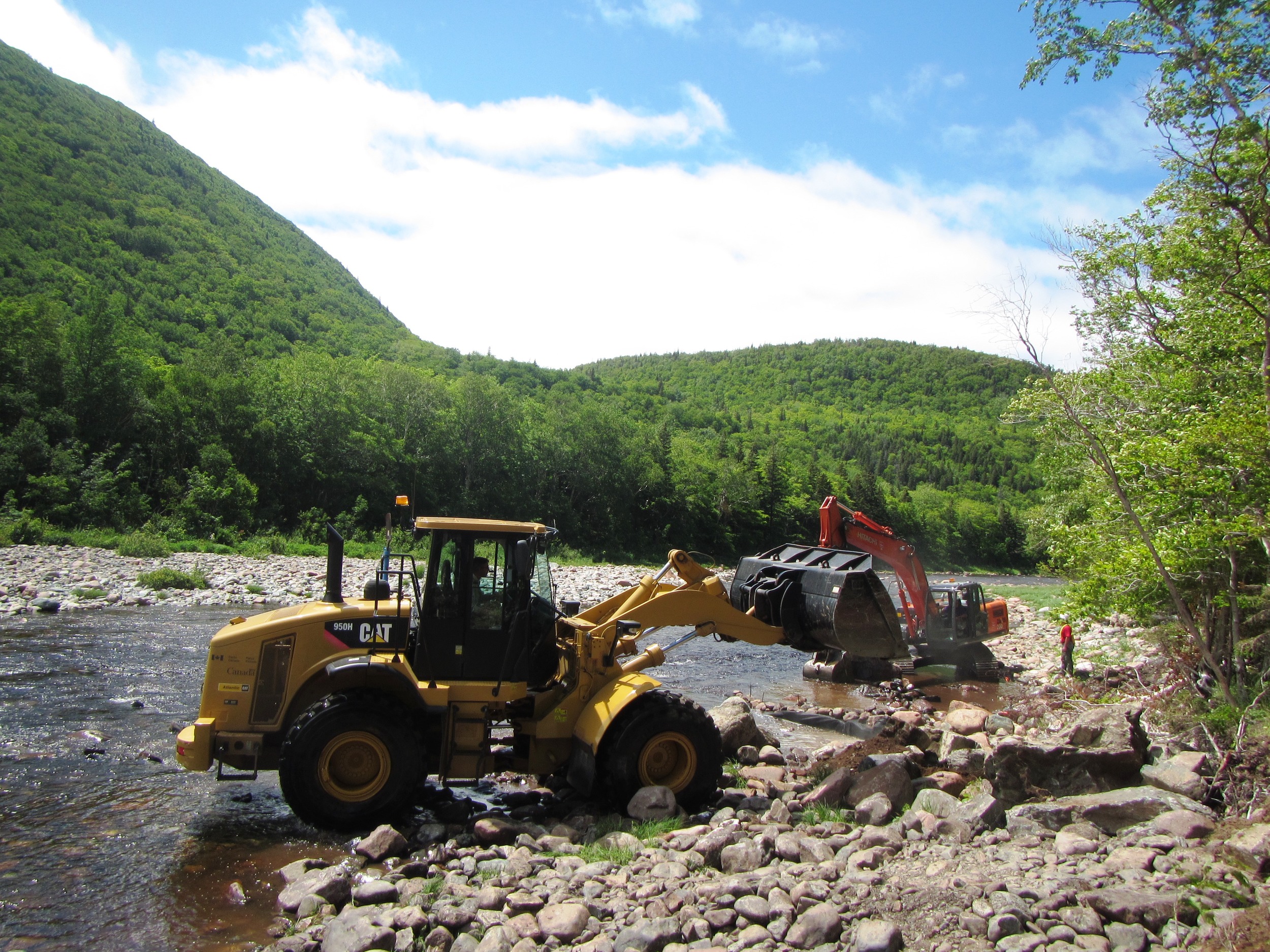 Heavy equipment working to install rock retarding bars above Fence Pool