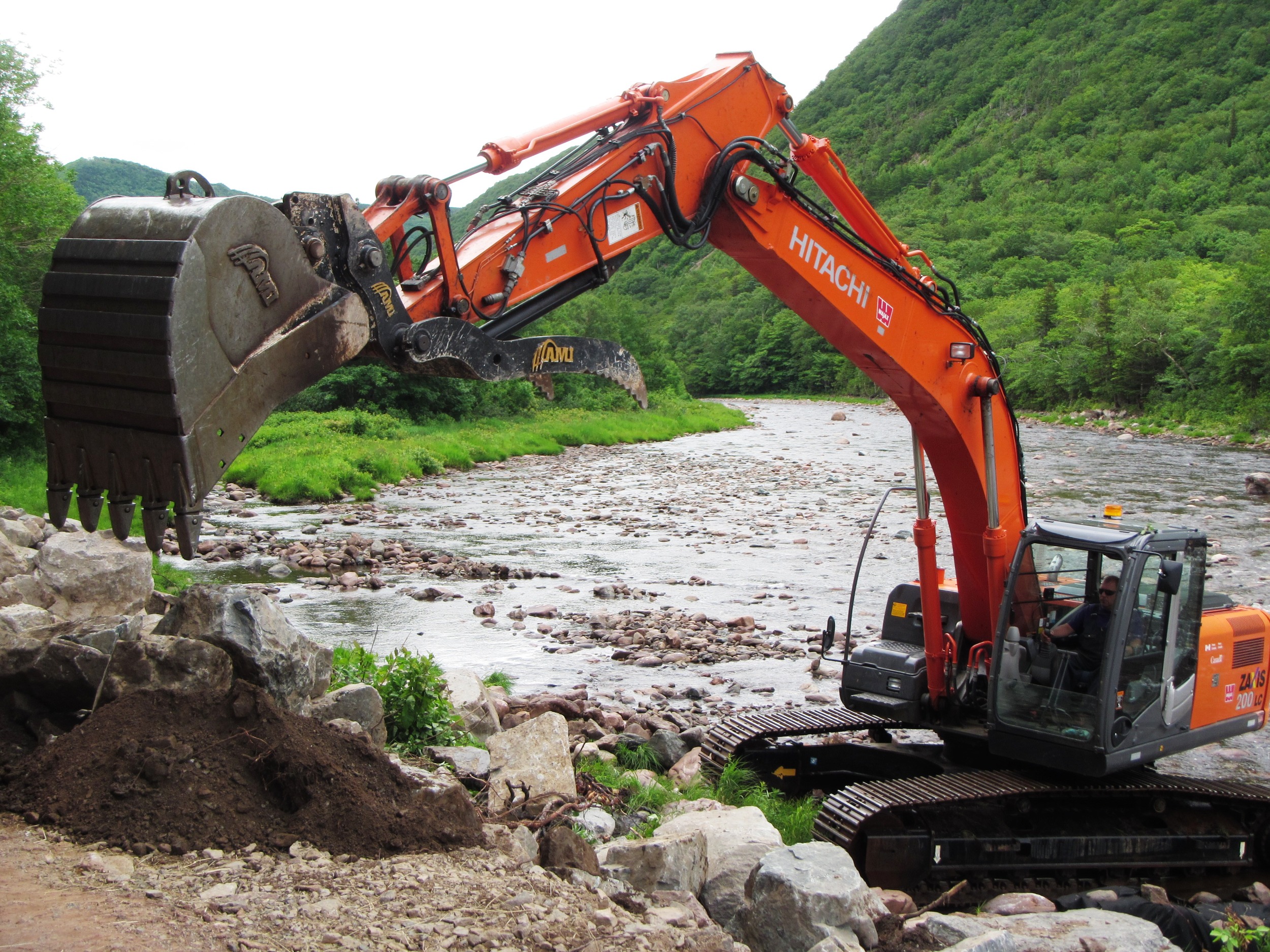 Excavator installing rock deflectors above Fence Pool