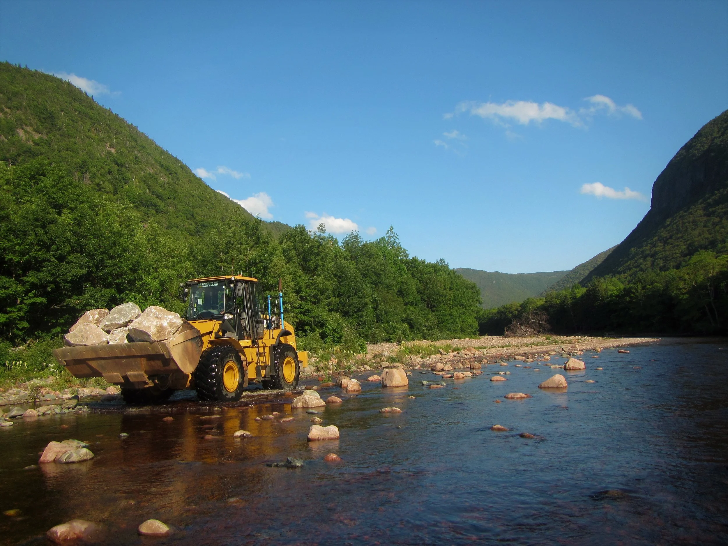 Front end loader moving rock to work sites below Fence Pool