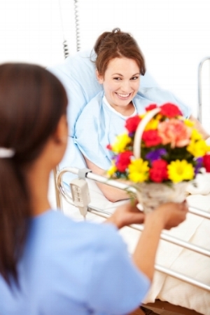 woman receiving flowers in hospital room