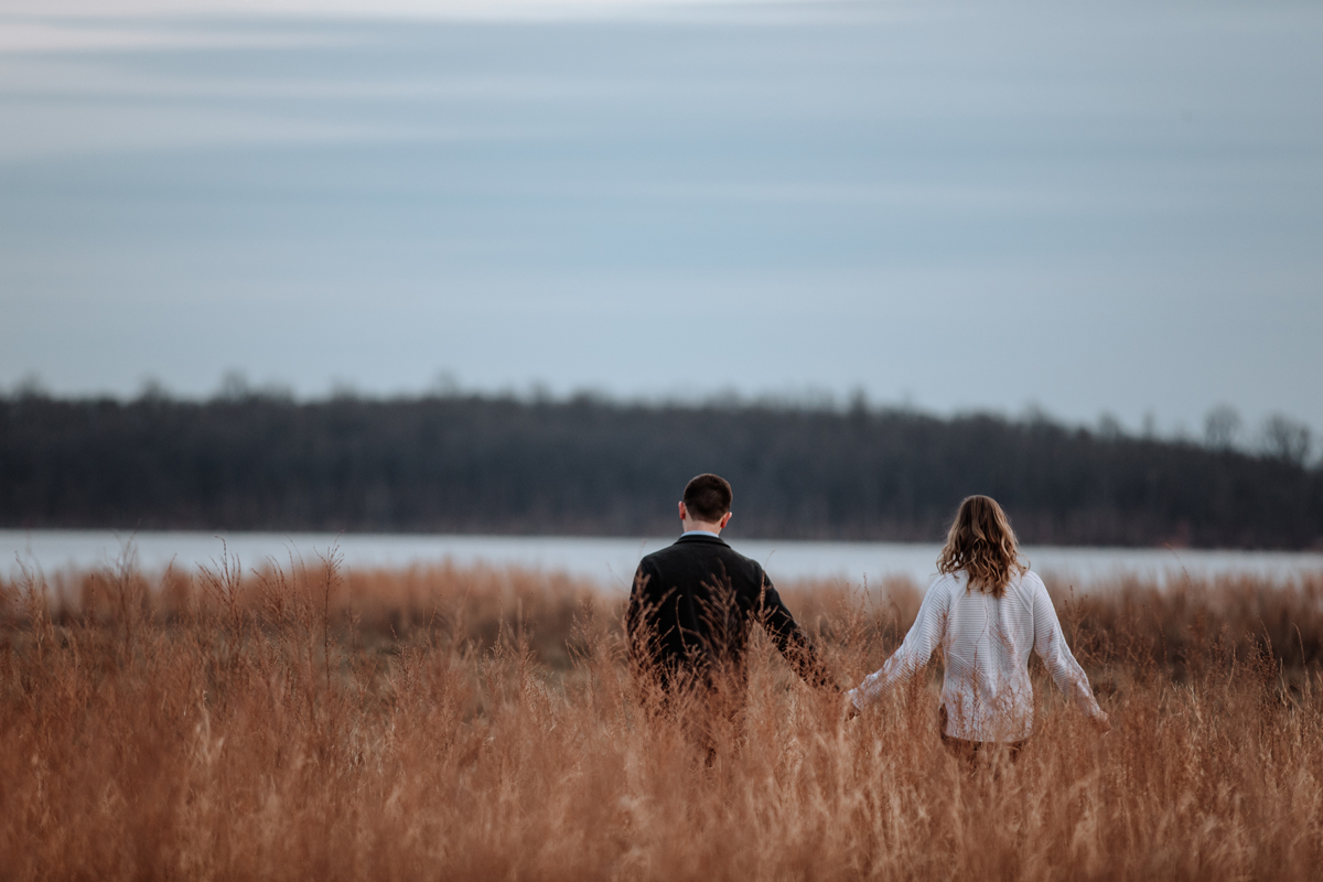 couple-walking-through-field-sunset-photos
