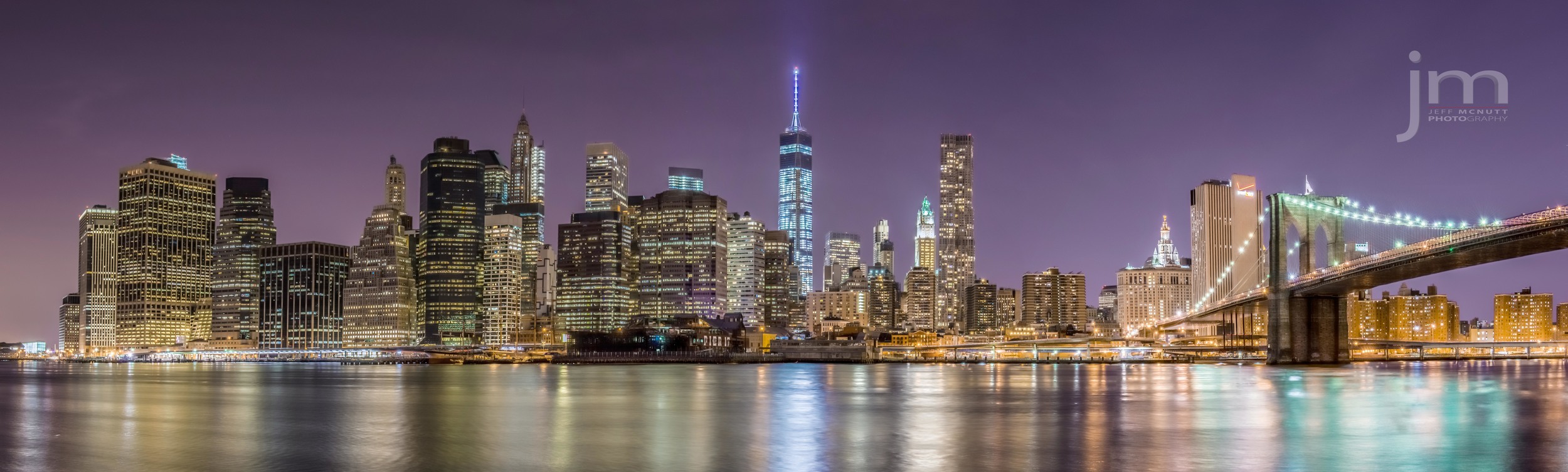 Panoramic shot of Manhattan and the Brooklyn Bridge from Brooklyn. Freedom Tower is standing in the center of this picture.