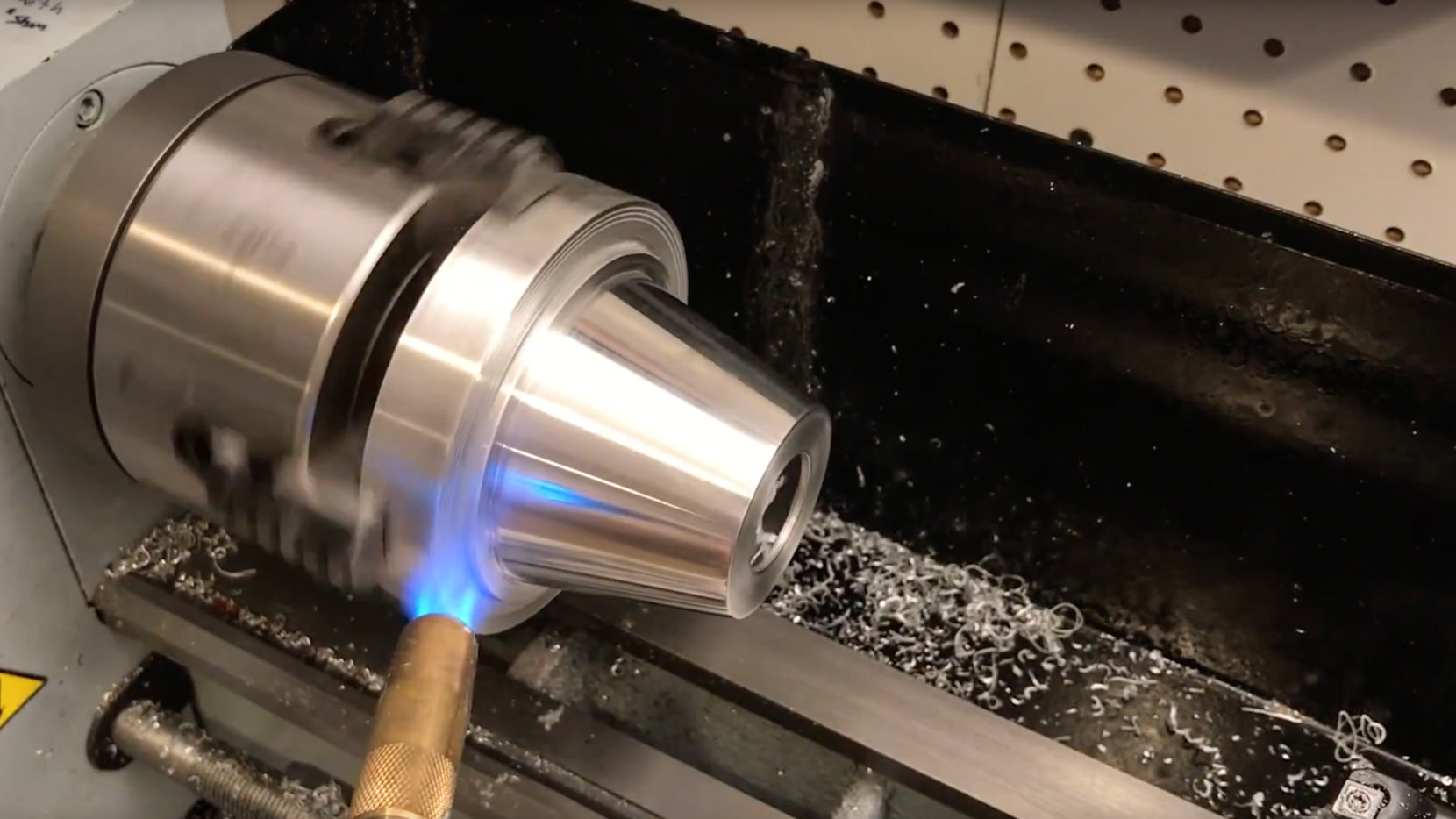 Here is is all machined and polished. I'm using a torch to break the super glue that is holding it to the shop made super glue arbor.