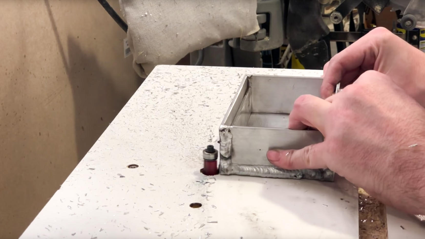 I use a router with a flush trim bit to lean the welds welds up.