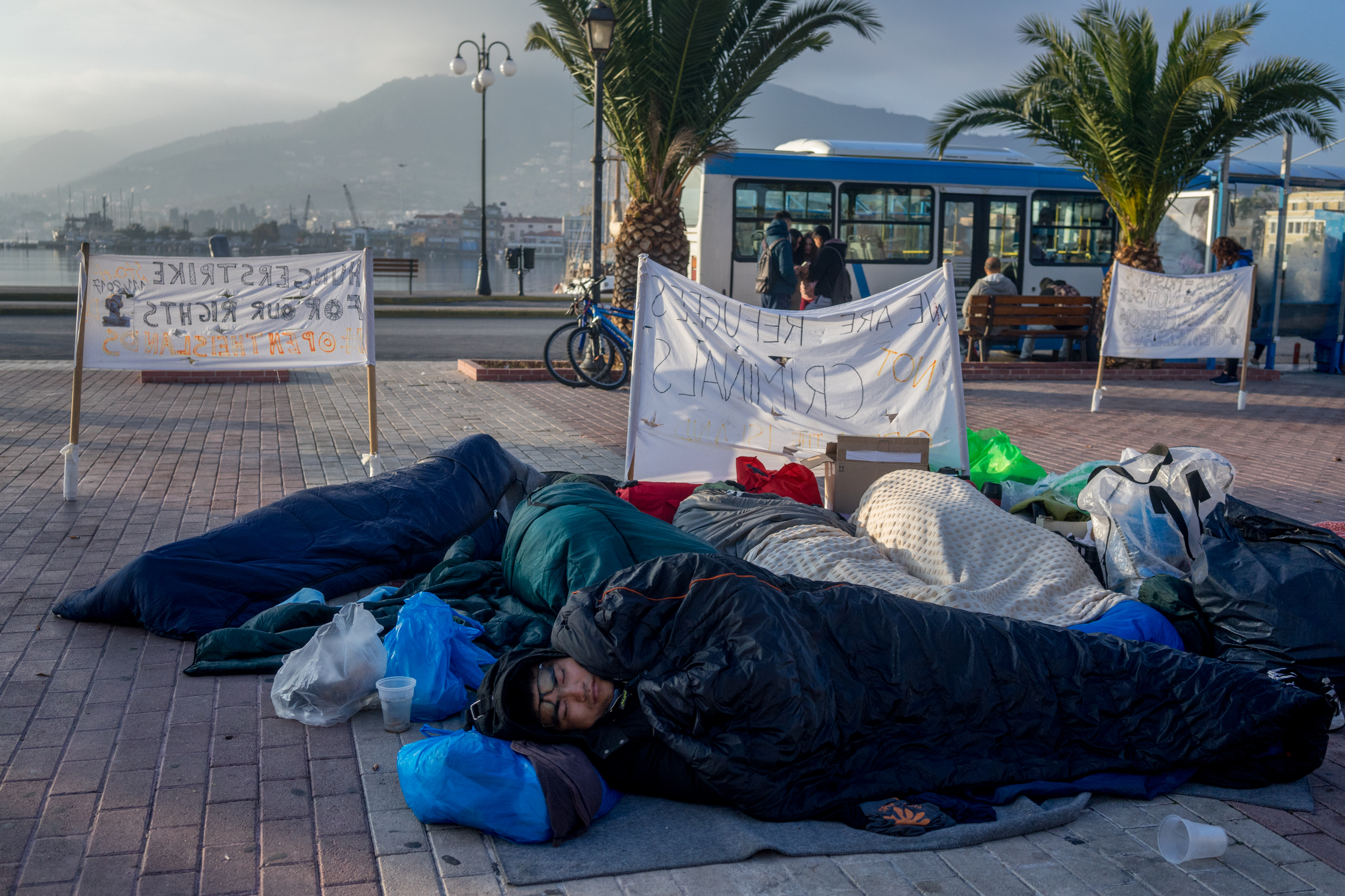 Sadegh from Afghanistan sleeps in the protest in Sappho Square. November 10, 2017. Sappho square, Mytilene, Lesbos, Greece. Fifteen days after this photograph was taken, demonstrators in the square were violently evicted by the police, forcing the refugees to find somewhere else to sleep, or go back to Moria.