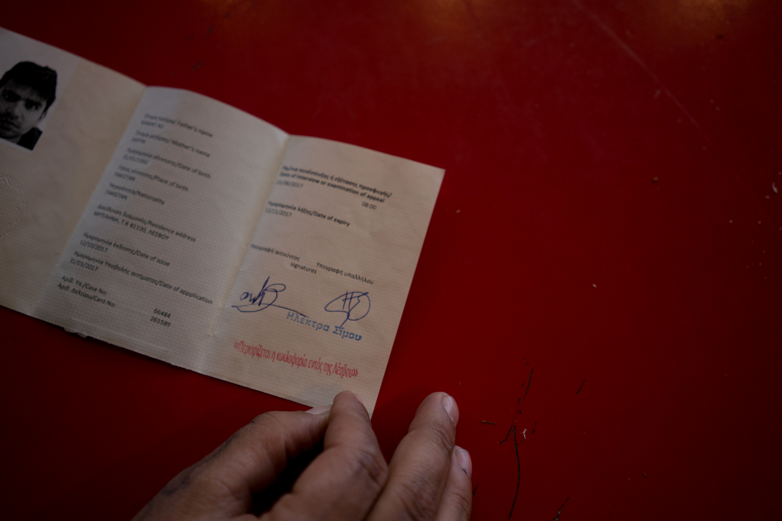 Every month, the asylum-seekers on Lesbos go to the European Asylum Support Office to renew their immigration cards. If they get a blue stamp, they can move to the mainland, but many of the asylum seekers have gone more than 10 times and received the red stamp that restricts them to the island at every visit. Simultaneously, deportations back to Turkey are increasing. In some cases, asylum seekers wait more than a year on Lesbos only to get deported. October 13, 2017. Moria camp, Lesbos, Greece An Asylum seeker shows his identity card with the red stamp means he cannot leave the island. 