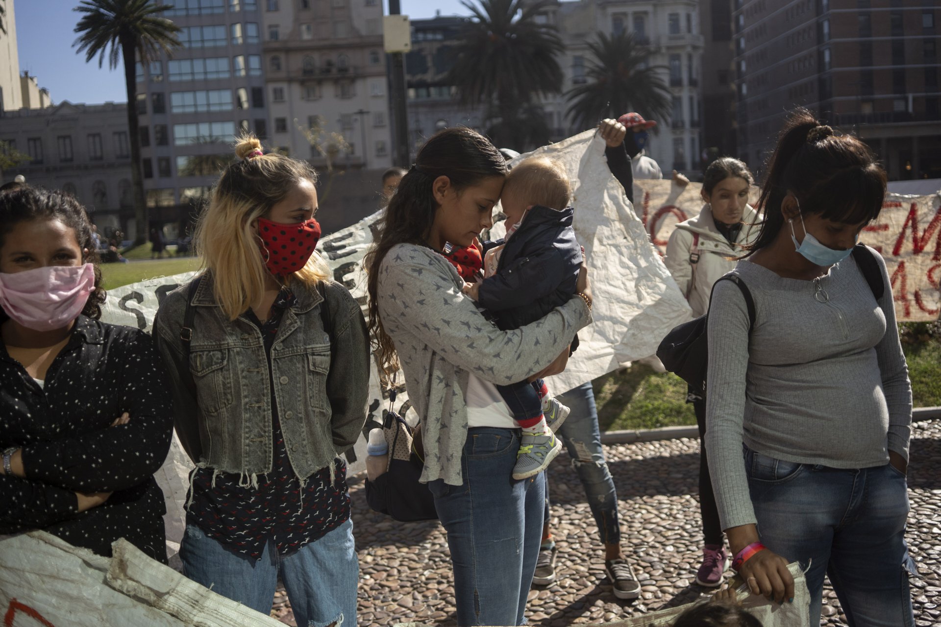 Tania holds her son Bautista in a protest in the center of Montevideo, asking to not get evicted. May 2020, Montevideo