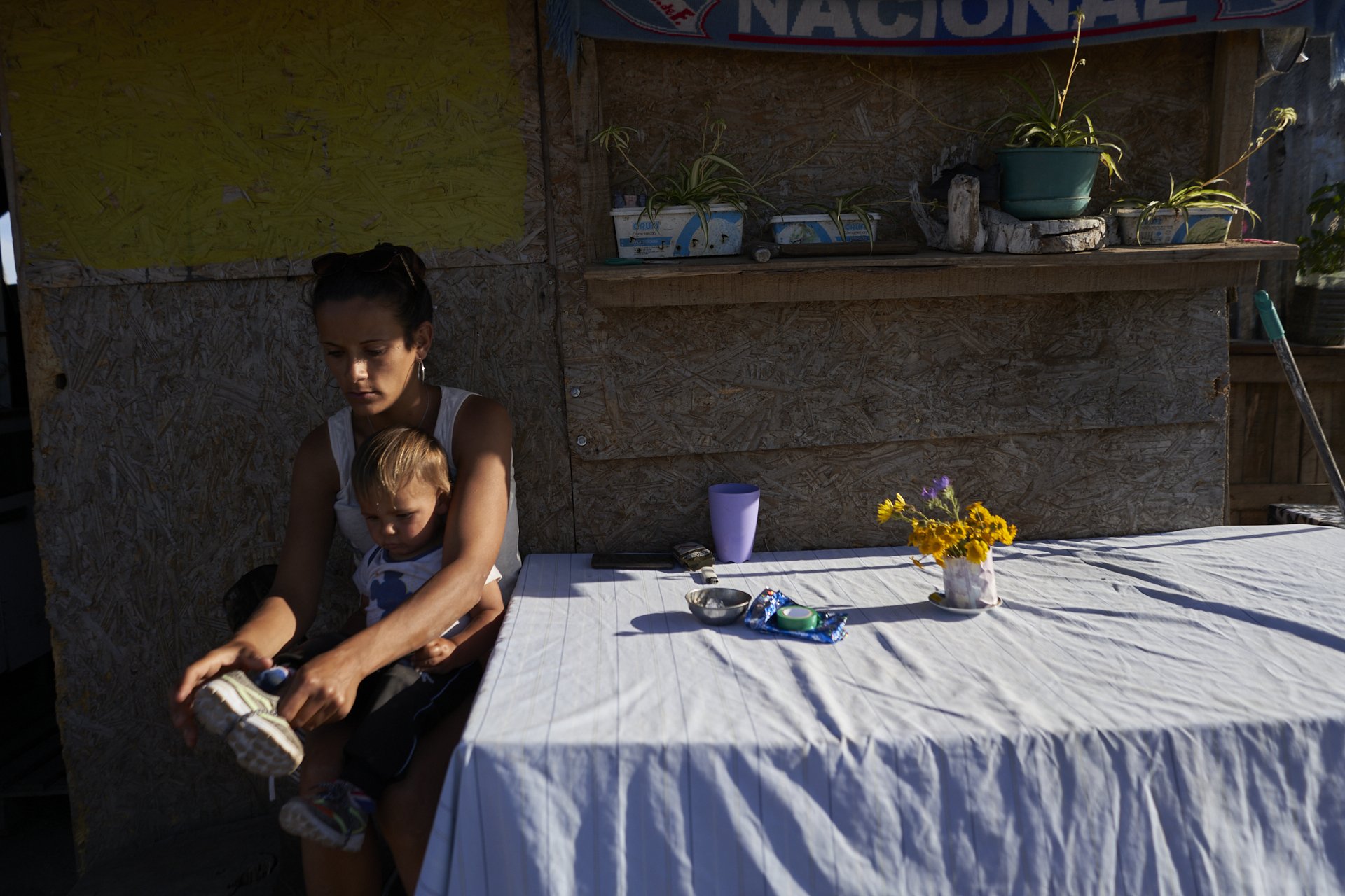 Tania helps Bauti puts his shoes. November 2020, Nuevo Comienzo