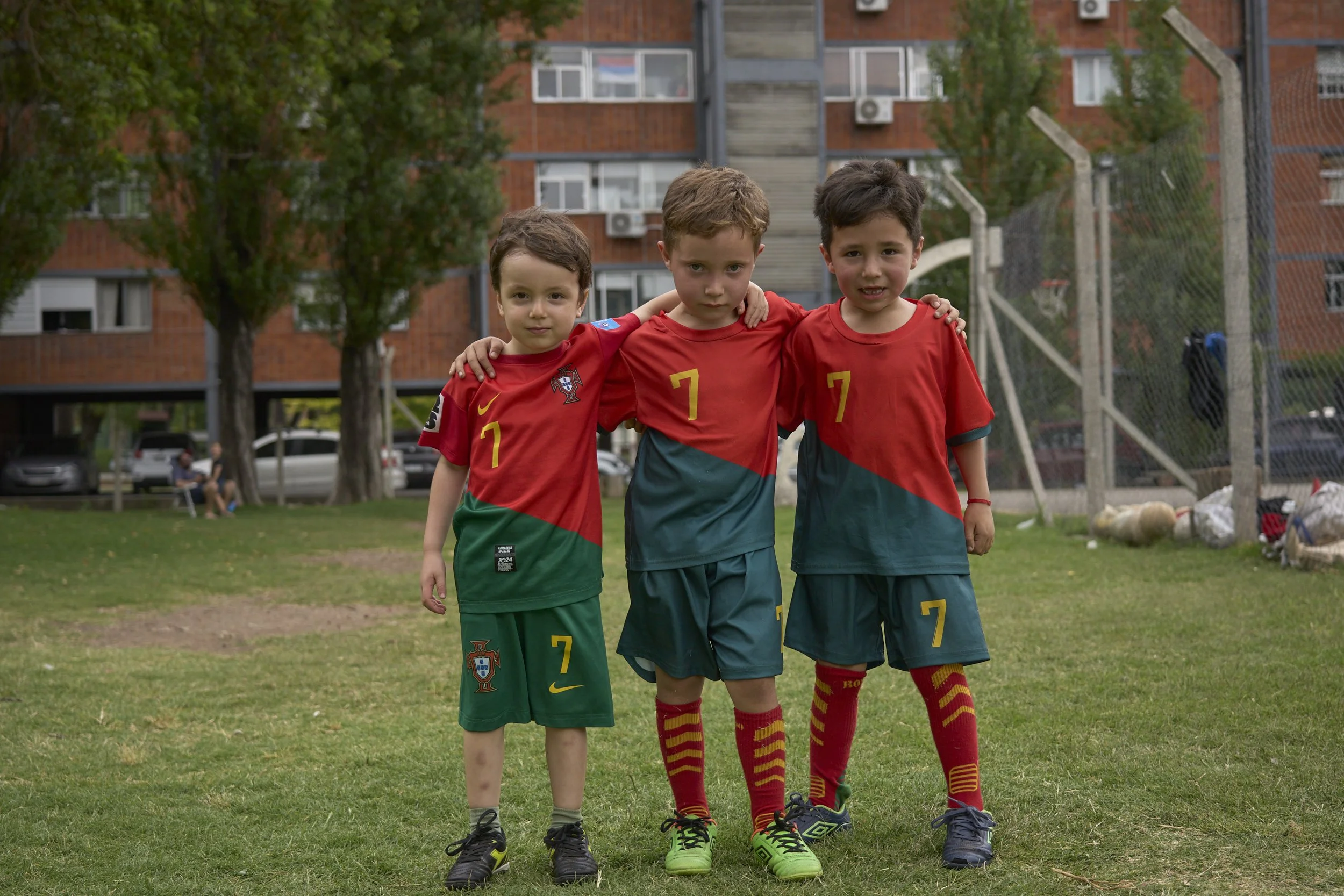  Friends Juan Cruz, Vichenzo and Angelo pose for a picture after a football training. Their trainer, Gron, is a neighbor that has been training kids and teenager for almost 40 years, and by doing so strengthening friendships. 