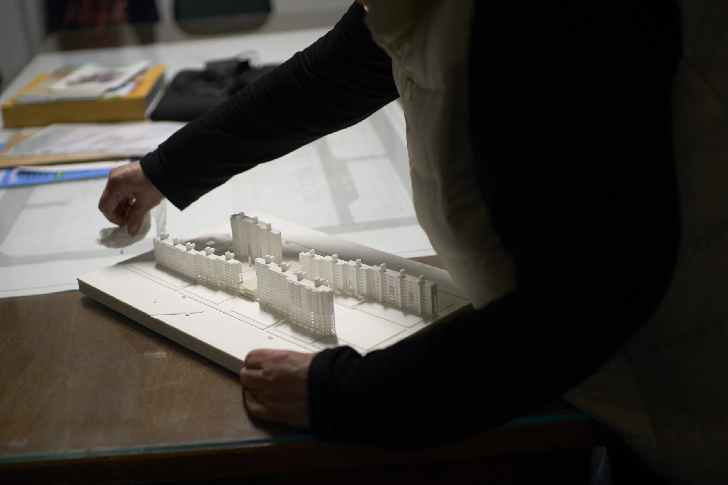  Cristina cleans a maquette of the Complejo, before a general meeting. 