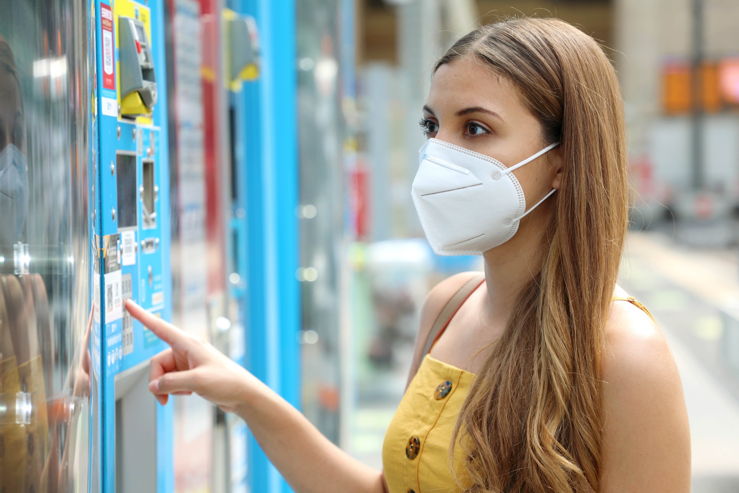 portrait-young-woman-with-protective-mask-kn95-ffp2-choosing-snack-drink-vending-machine-train-station-vending-machine-with-girl (1).jpg