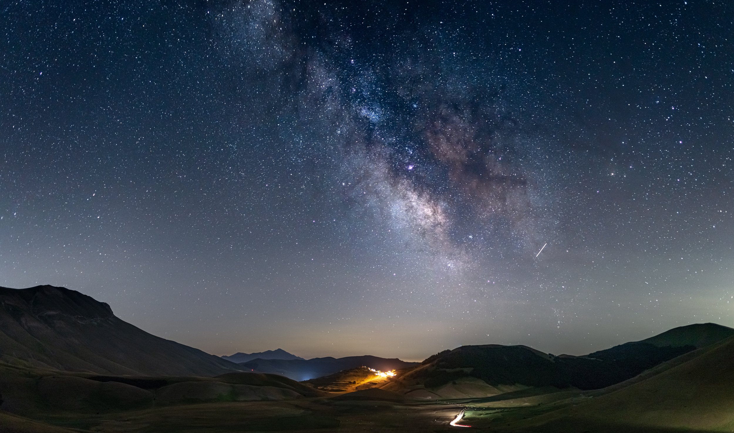 night-sky-castelluccio-di-norcia-highlands-italy-milky-way-galaxy-core-stars-illuminated-village-unique-hills-landscape.jpg