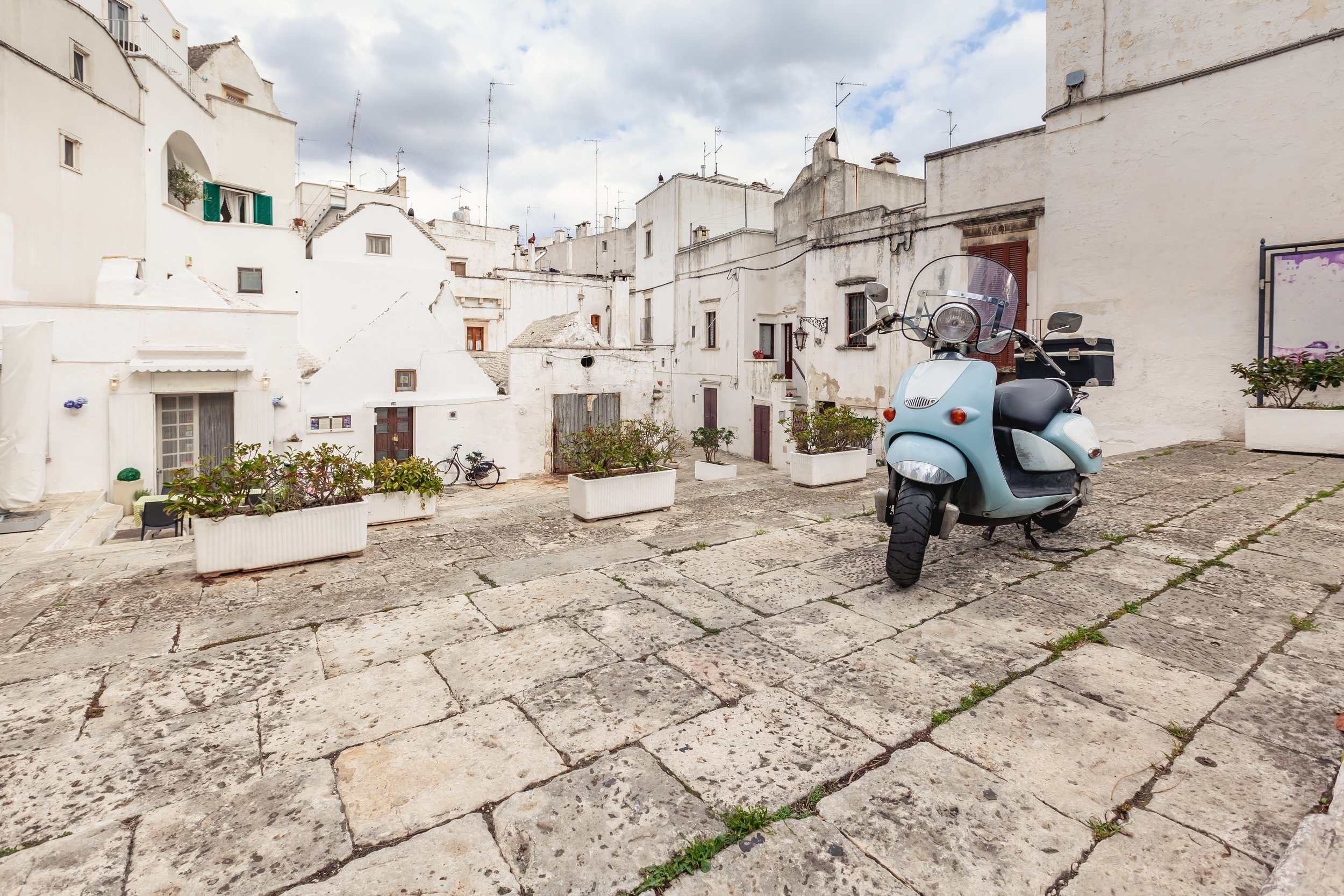 wonderful-view-empty-streets-old-town-martina-franca-with-beautiful-houses-painted-white-greenery-classic-blue-moped-background-anient-buildings-nice-day-touri.jpg