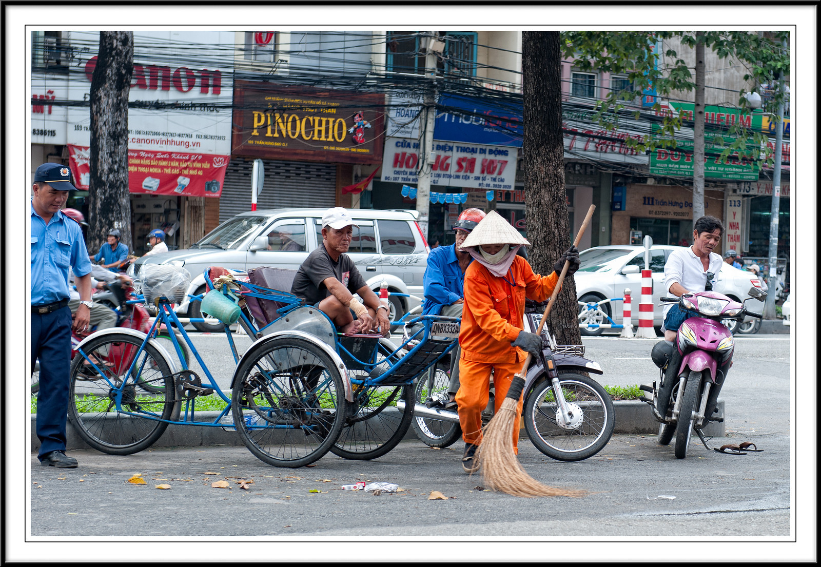      

 
  A woman cleaning the streets in Saigon while the men are busy watching.
 






















     